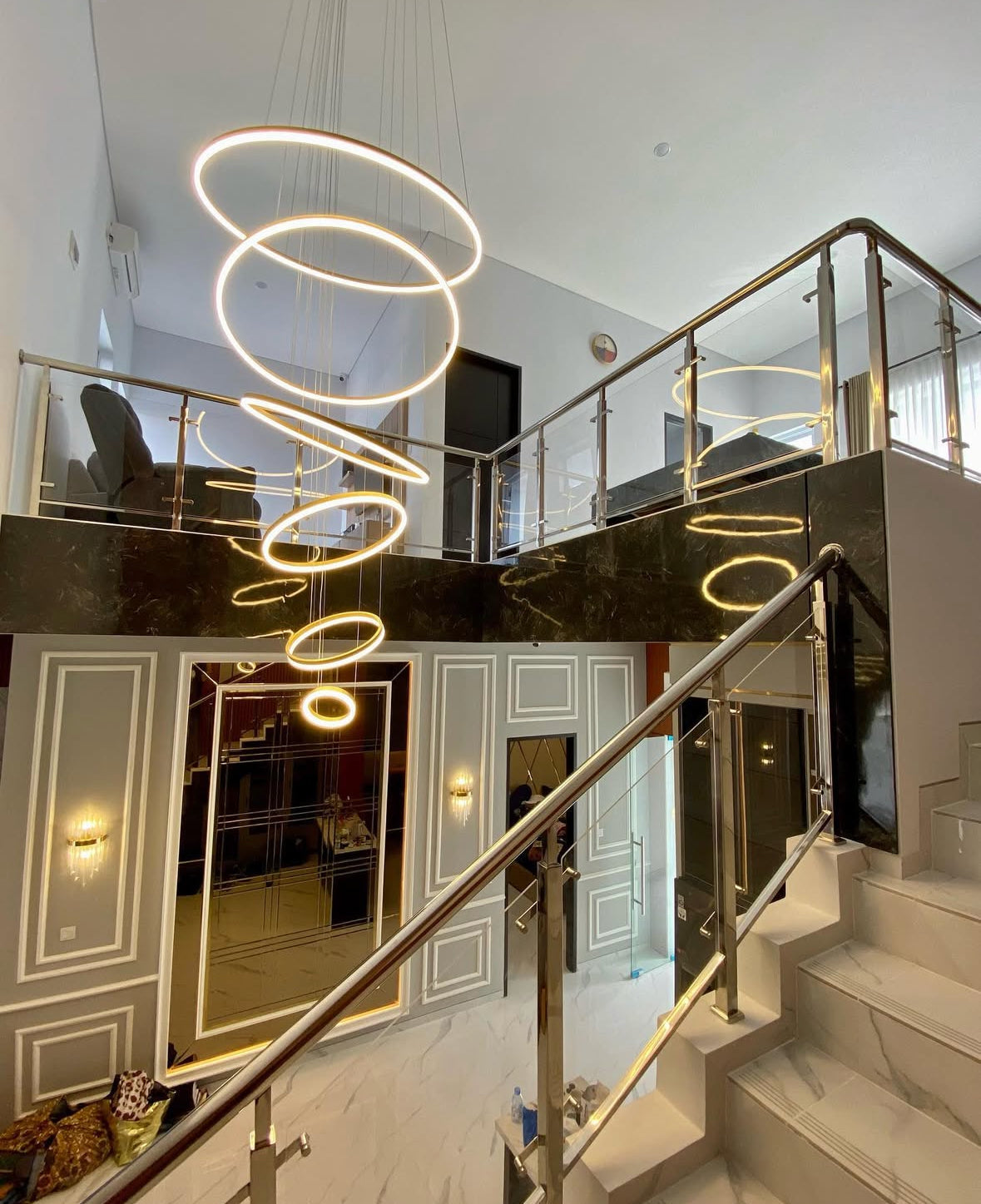Ring staircase chandelier suspended through a double-height stairwell void