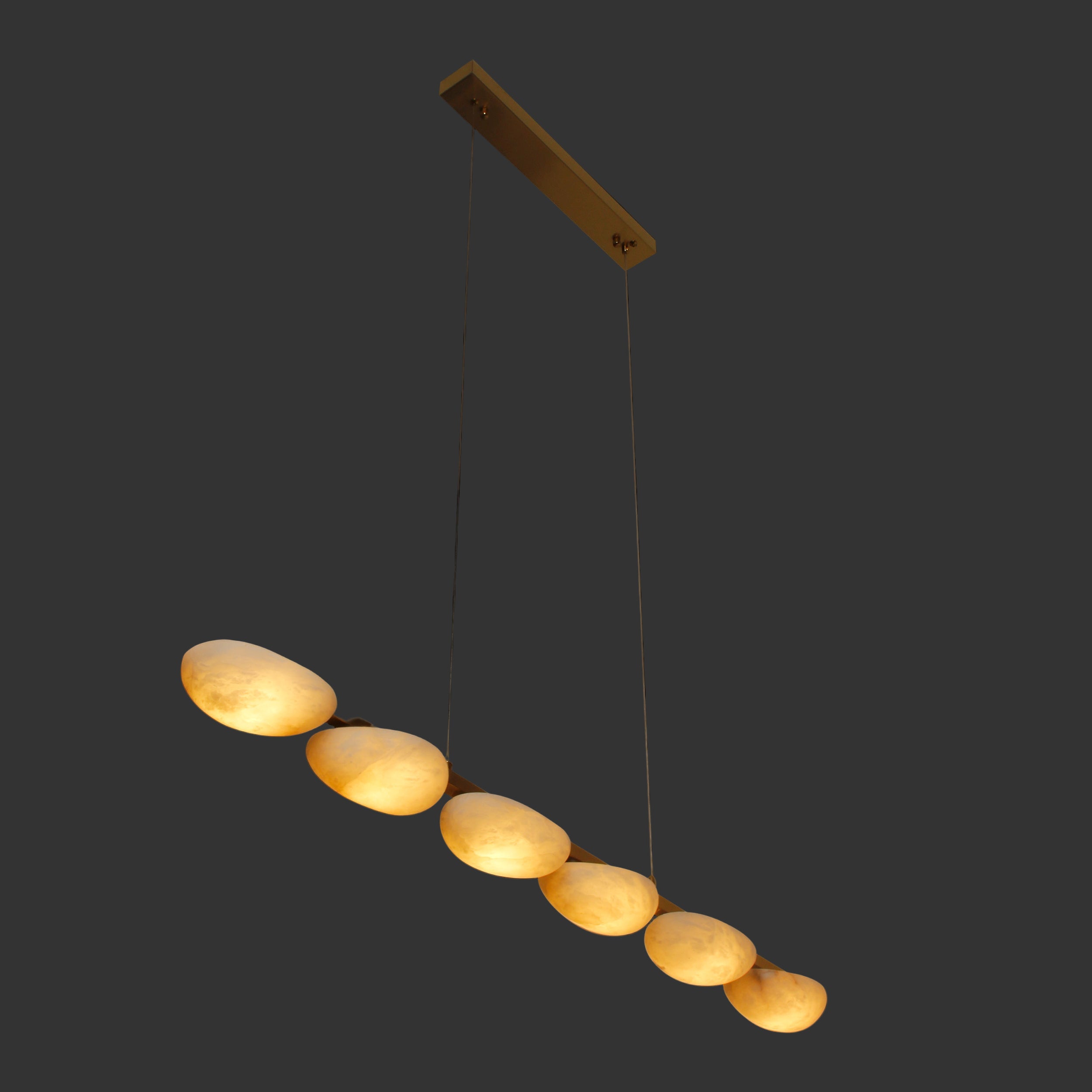 VORELLI® Alba Marble Rectangular Chandelier suspended in a linear form, glowing warmly in a dark ambient setting