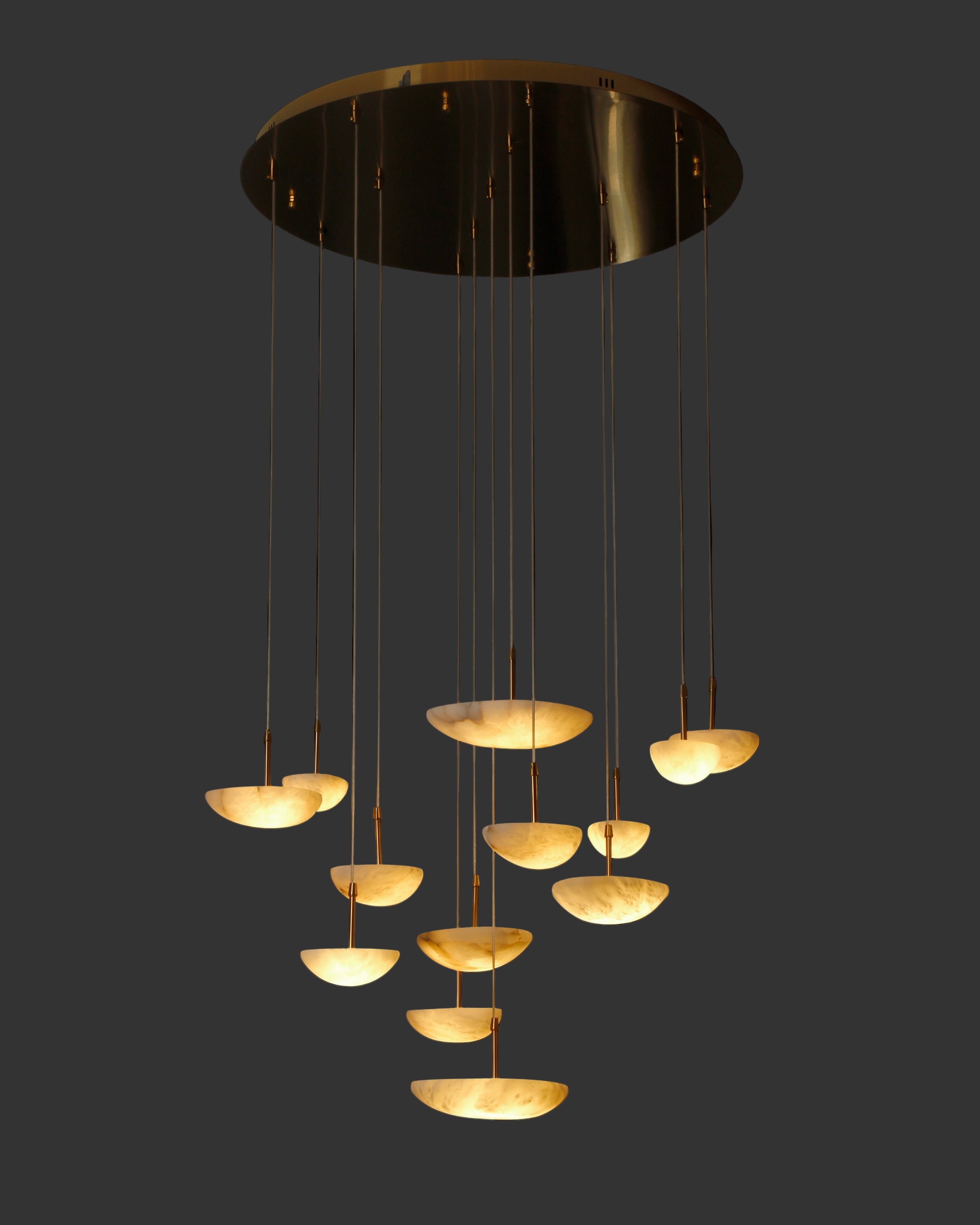 VORELLI® Alba Marble Pendant Staircase Chandelier with cascading hand-carved marble pendants glowing against a dark background