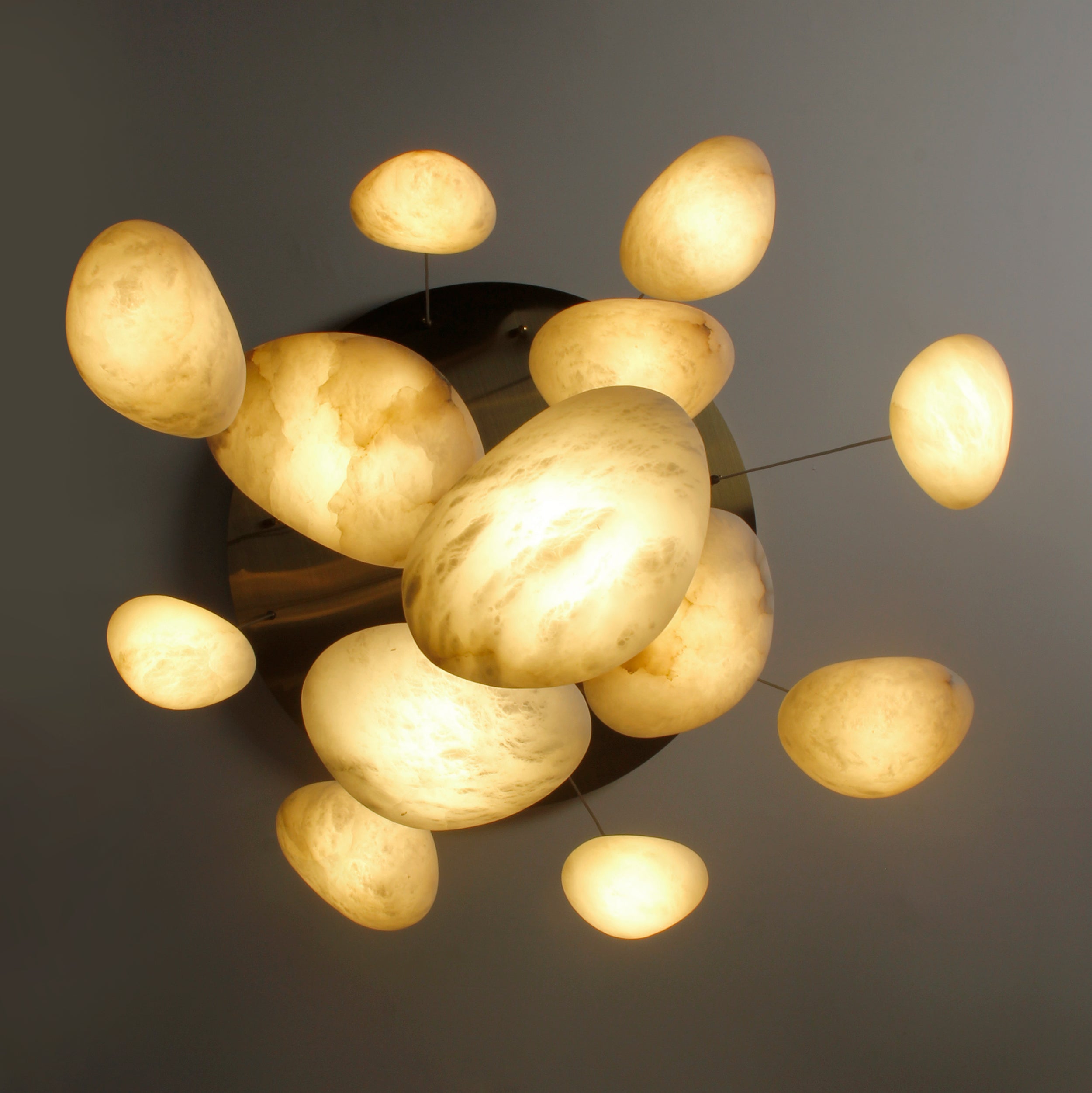 Top-down view of VORELLI® Alba Marble Staircase Chandelier showing symmetrical stone pattern and glowing veins