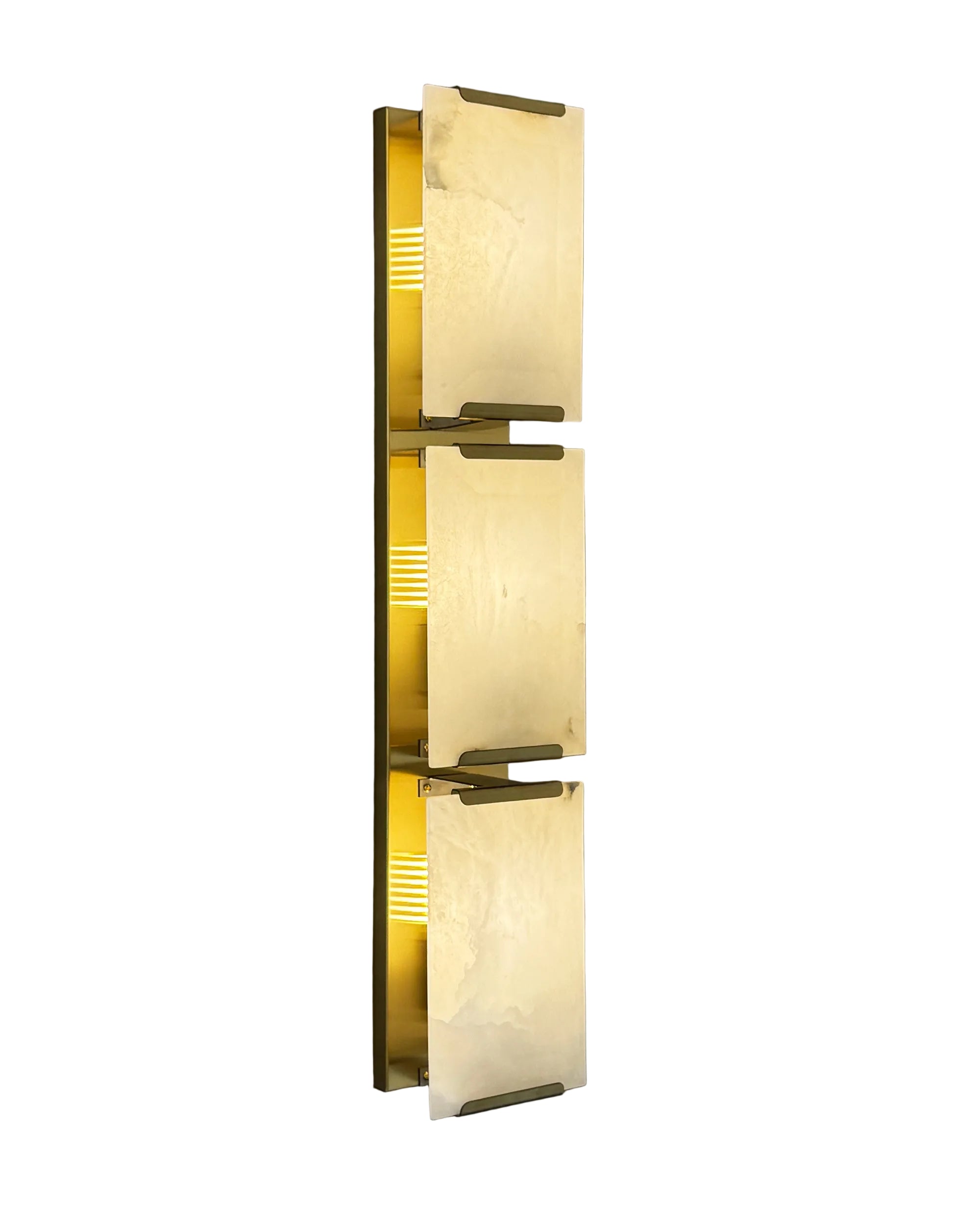 Angel Marble Wall Light II glowing warmly with layered marble and brass detailing, set against a dark grey wall.