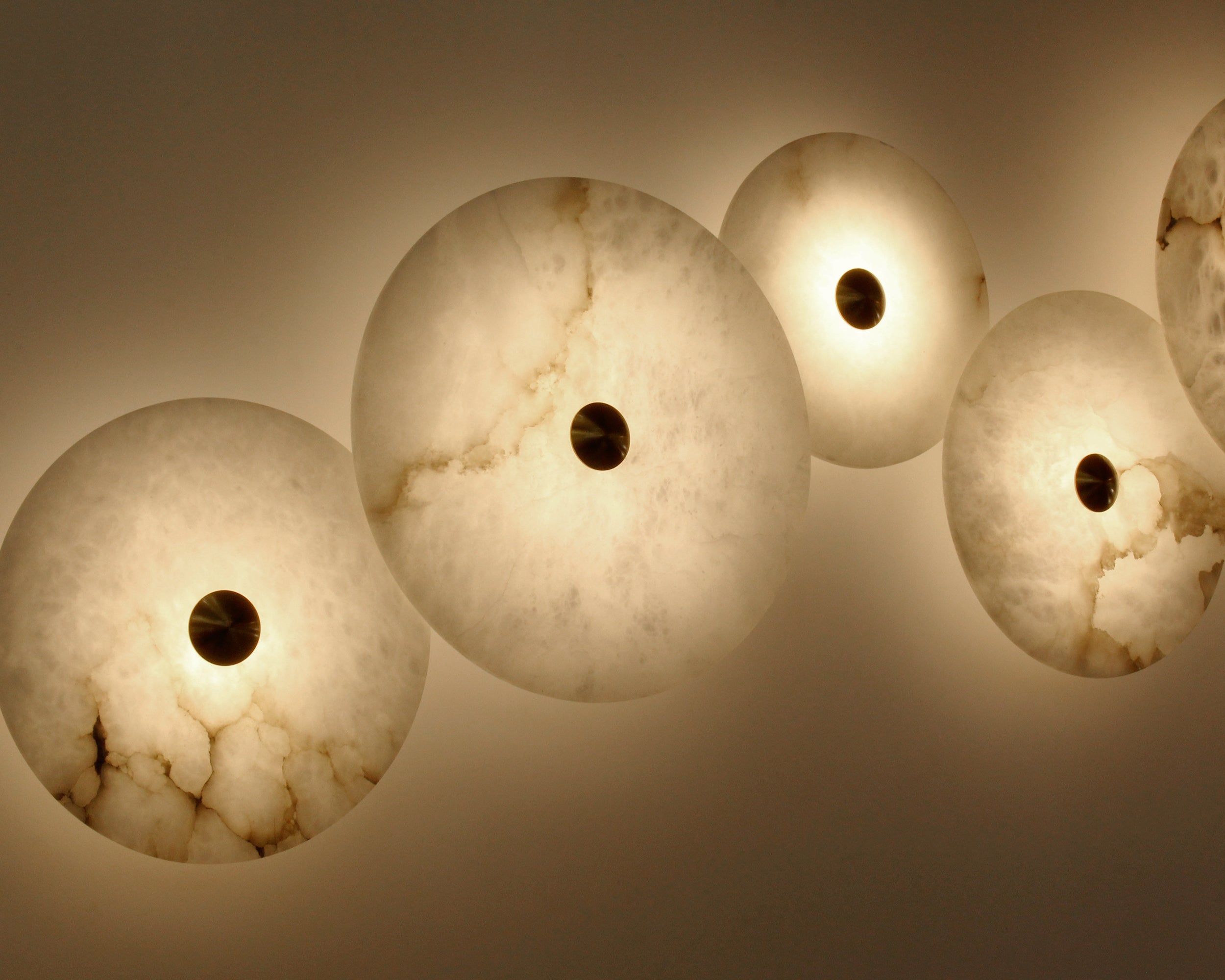 Angled perspective of the Aria wall lights installed in a flowing, curved line.