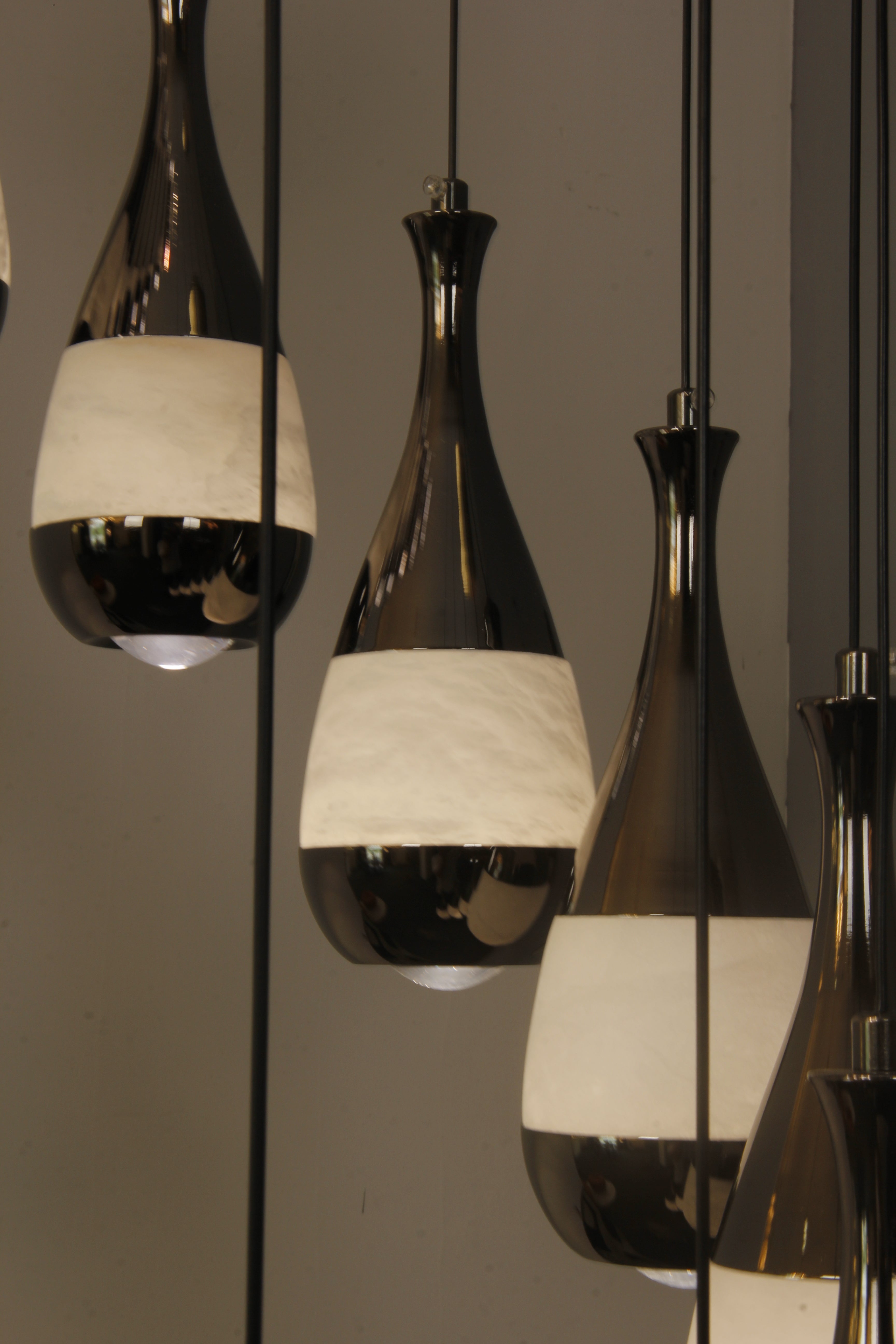 Hanging marble globes from the Armonia chandelier captured in a refined staircase setting.