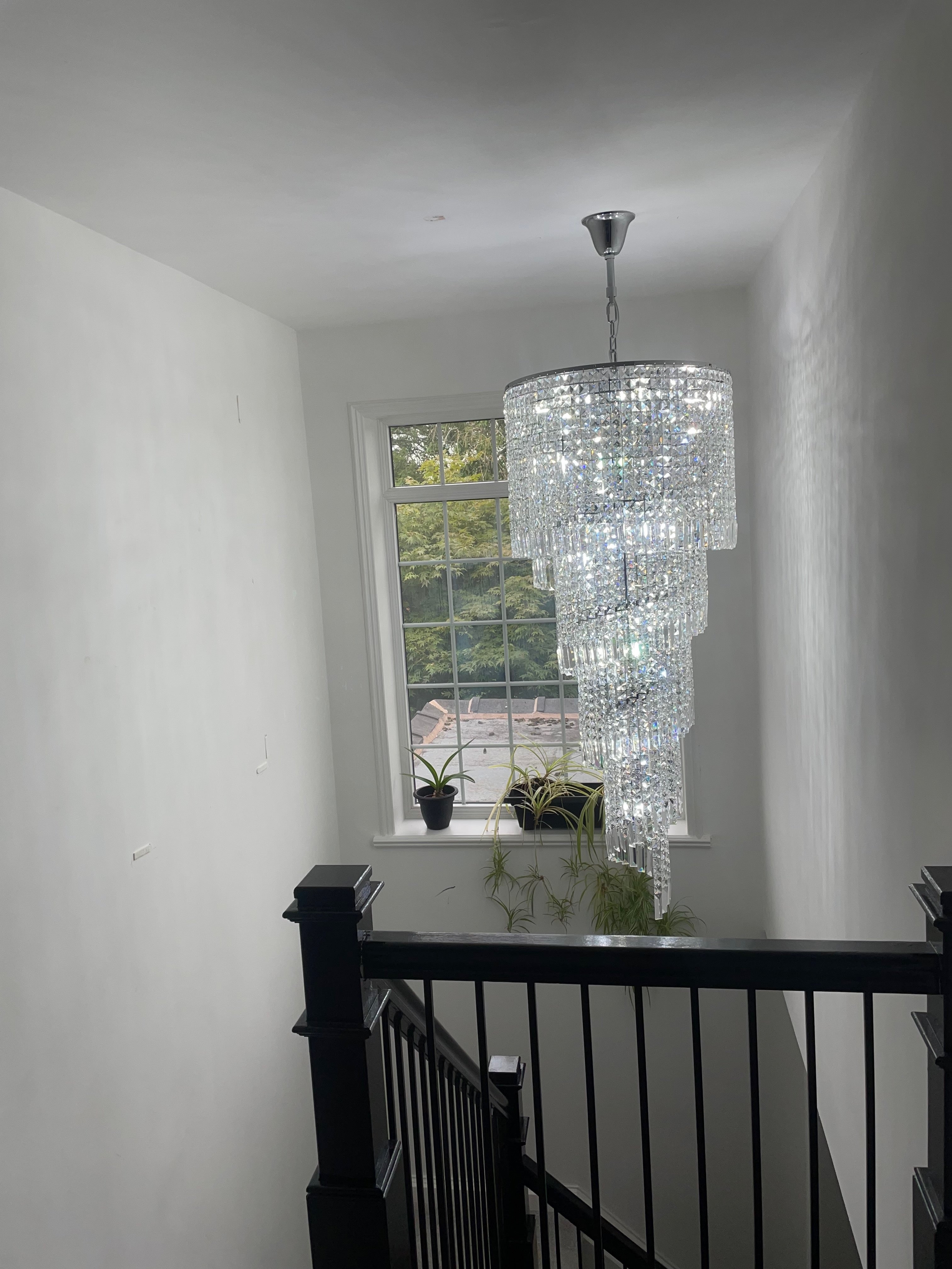 Basiglio cascading crystal staircase chandelier installed over a stair landing
