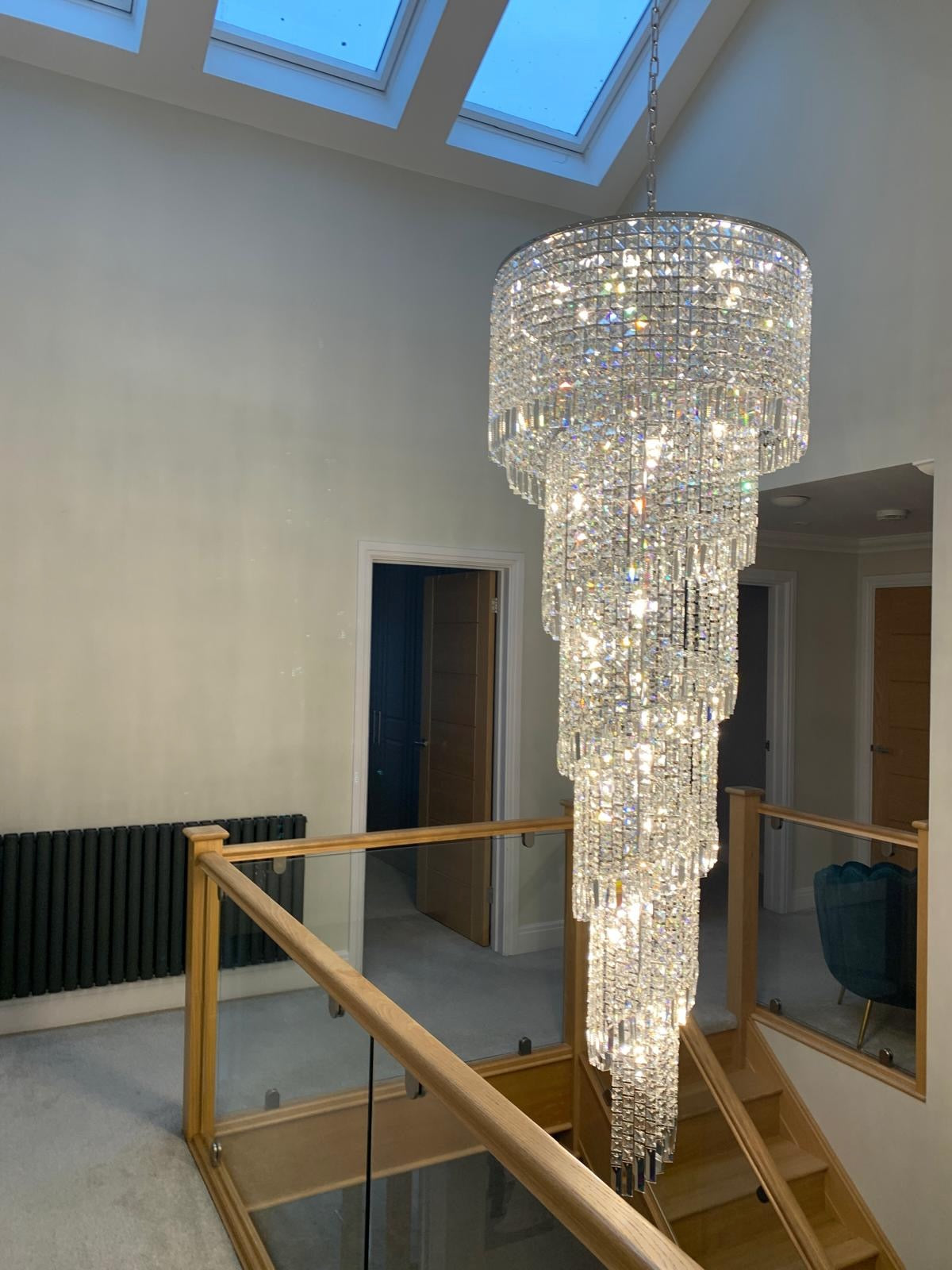 Basiglio long staircase chandelier cascading crystal design in a double height hallway