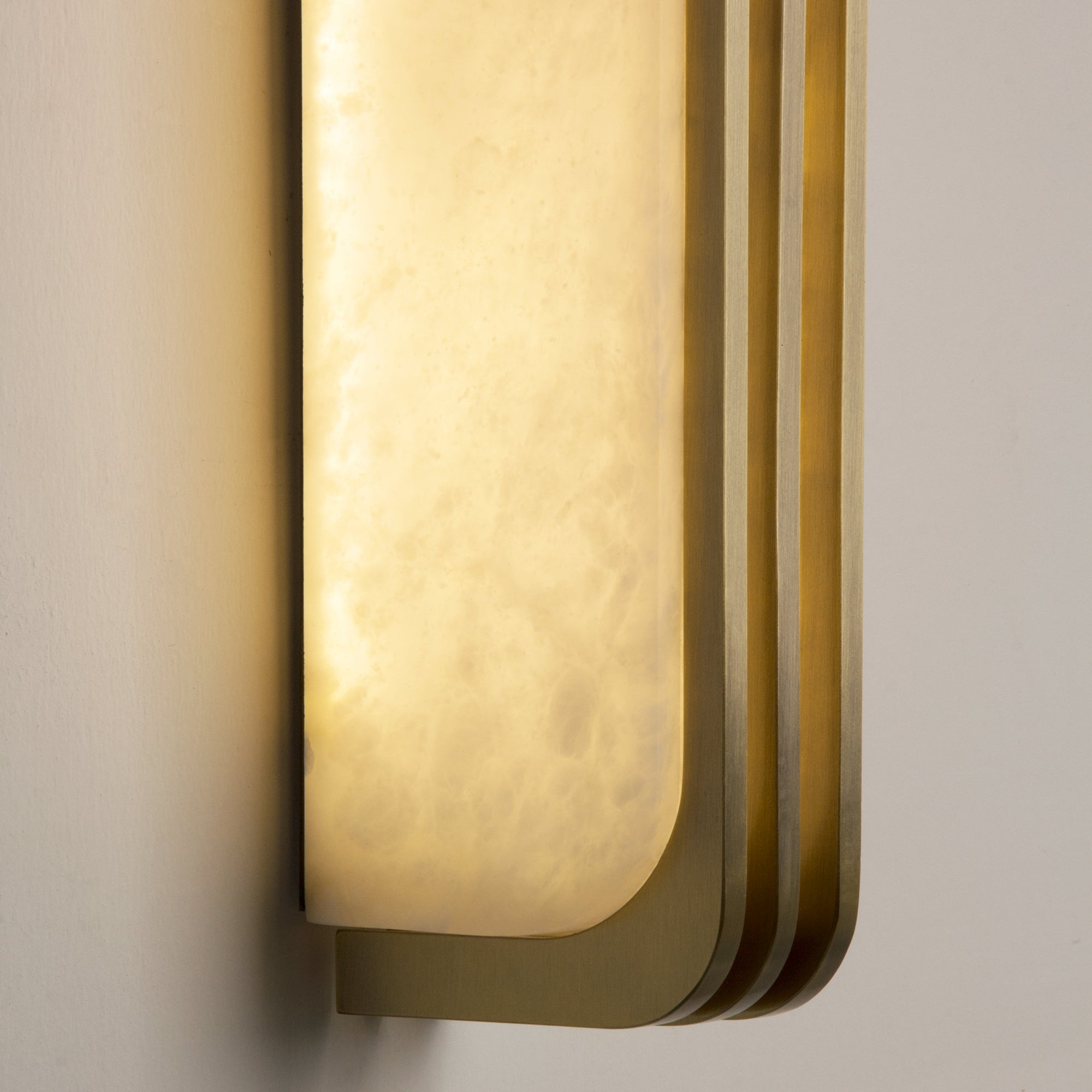 Side profile close-up of the Bellagio marble wall light showing its sculpted layered contours.