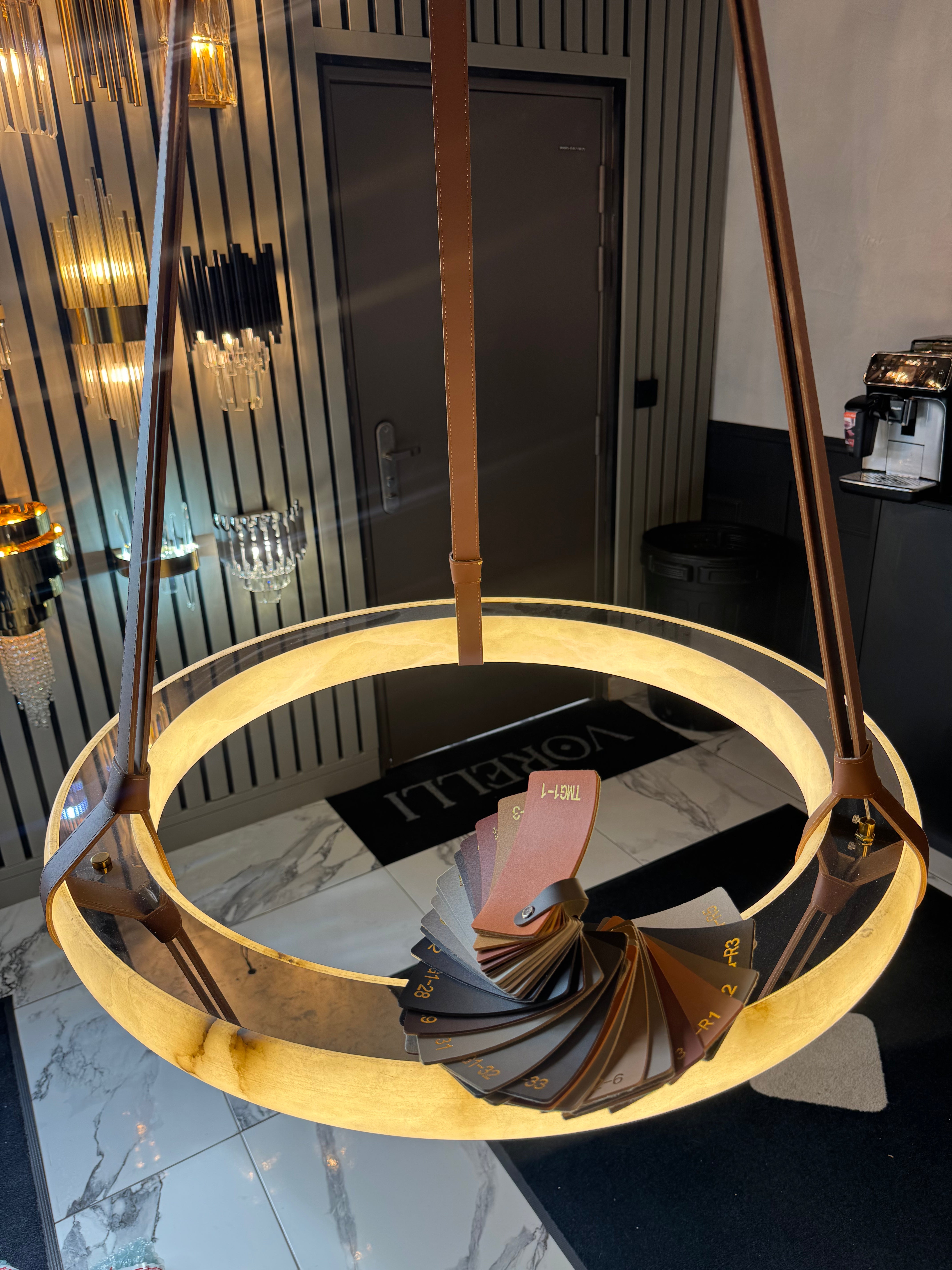 Warm-lit Botticino Marble Circular Chandelier showcasing the illuminated marble ring and suspended leather straps