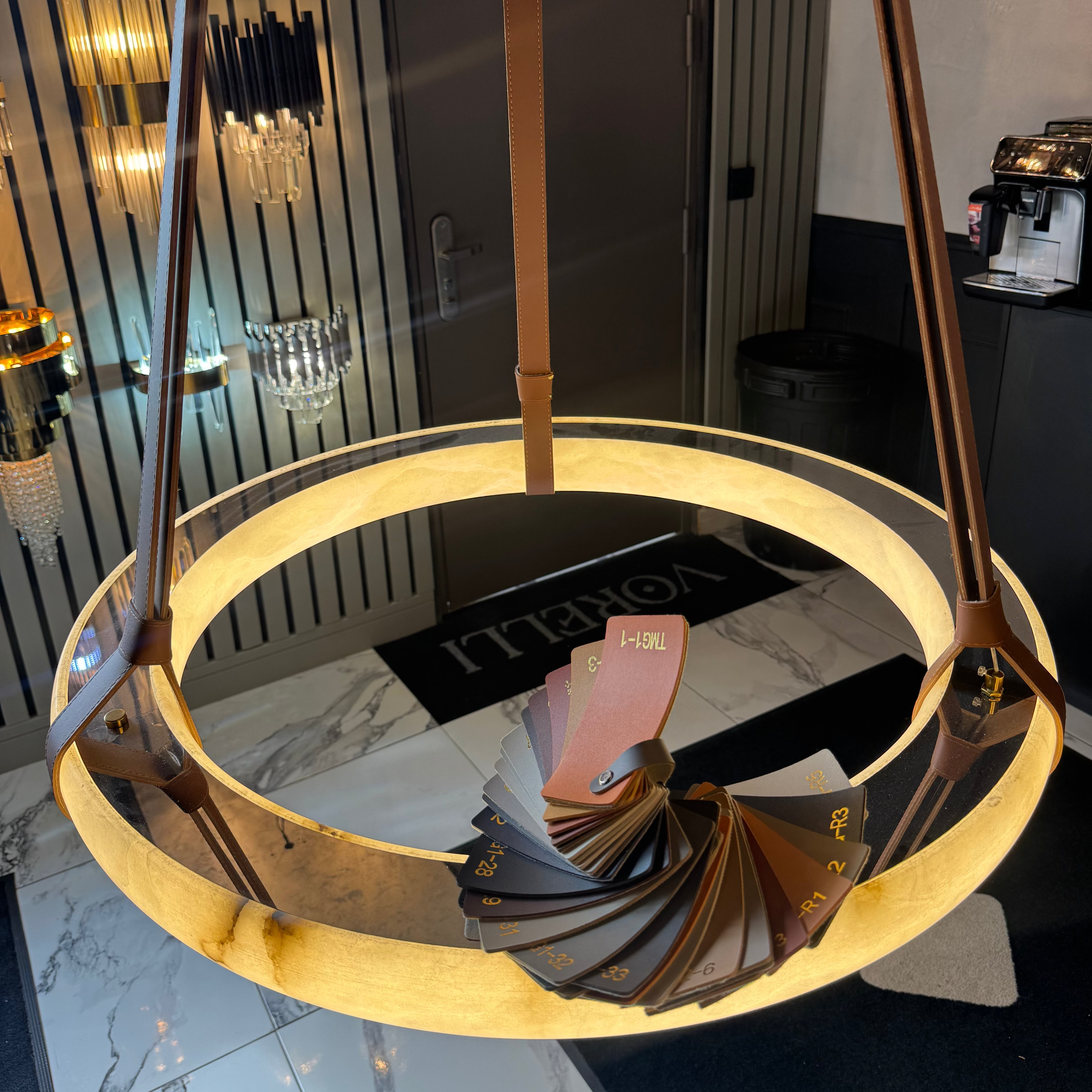 Warm-lit Botticino Marble Circular Chandelier showcasing the illuminated marble ring and suspended leather straps
