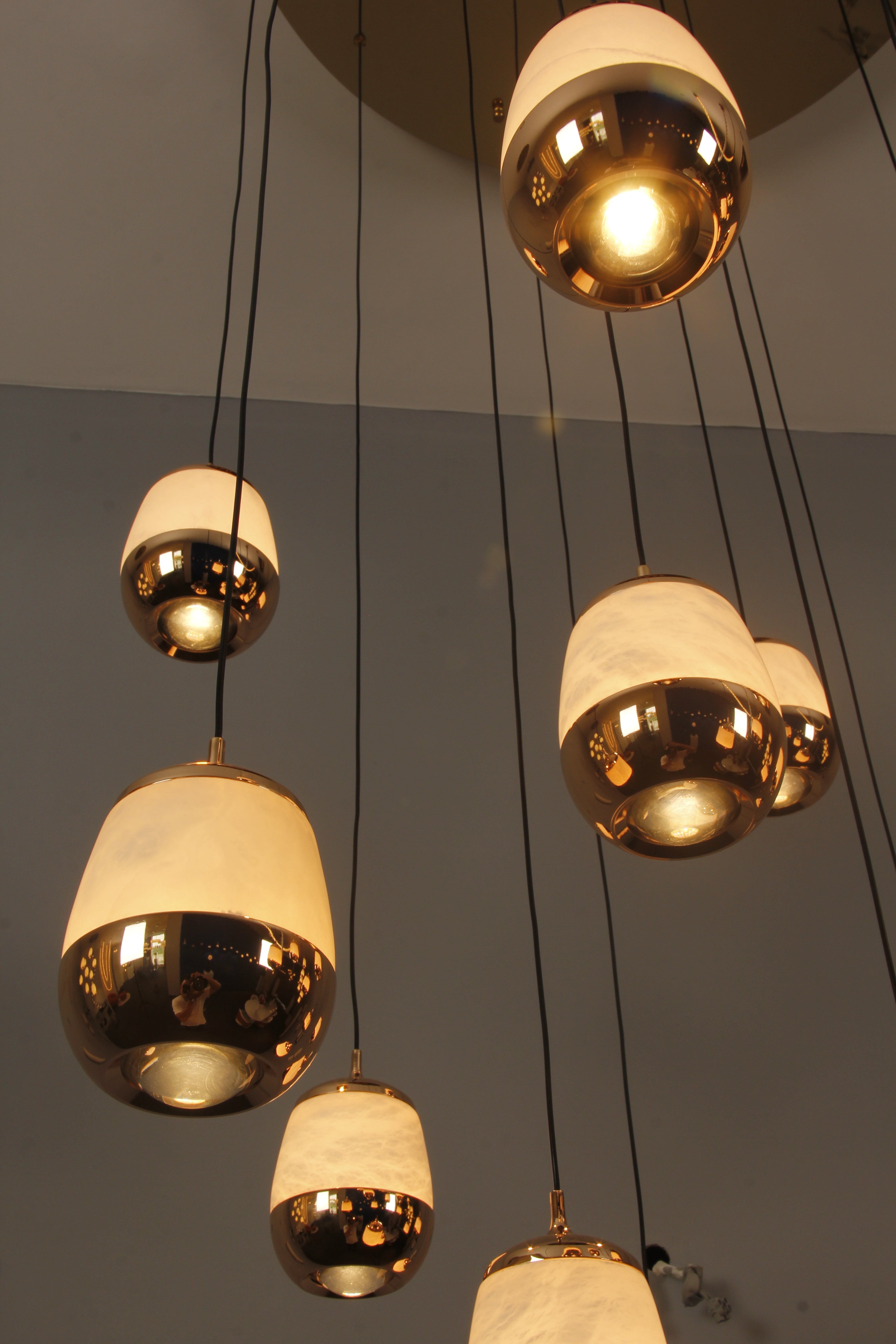 Angled view of suspended Caldera marble pendants revealing depth and cascading vertical movement.
