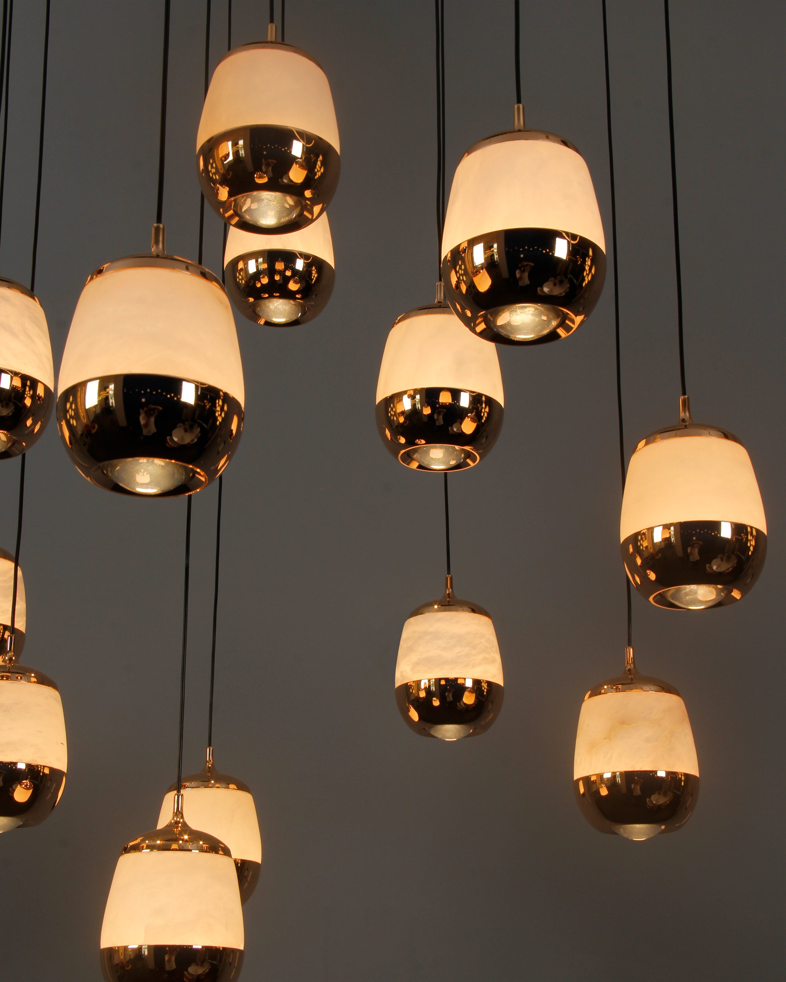 Close-up of Caldera marble pendants showcasing warm ambient illumination in a cascading formation.