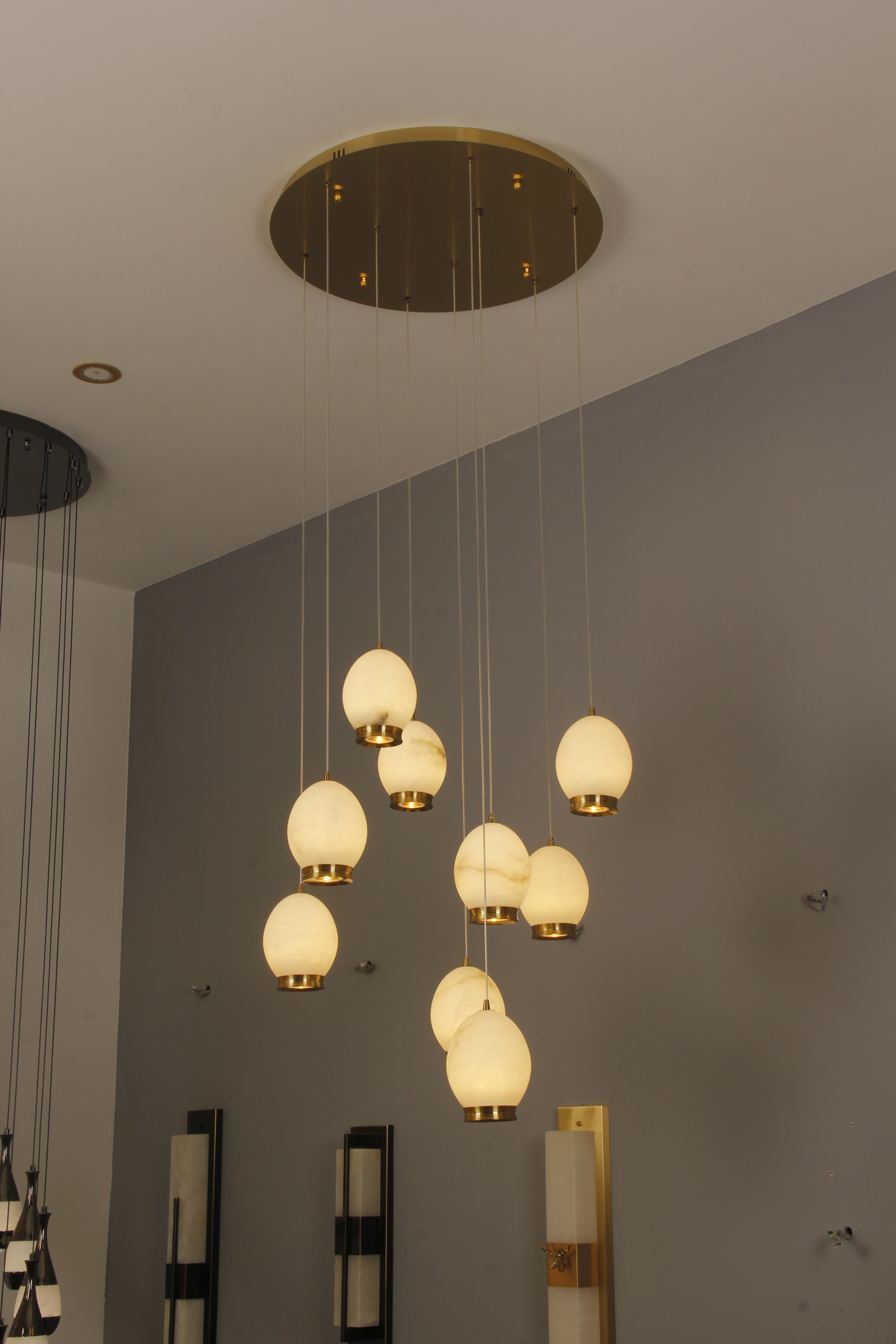 Caledonia Marble Staircase Chandelier installed in a modern interior, featuring cascading marble globes for a luxurious ambient effect.