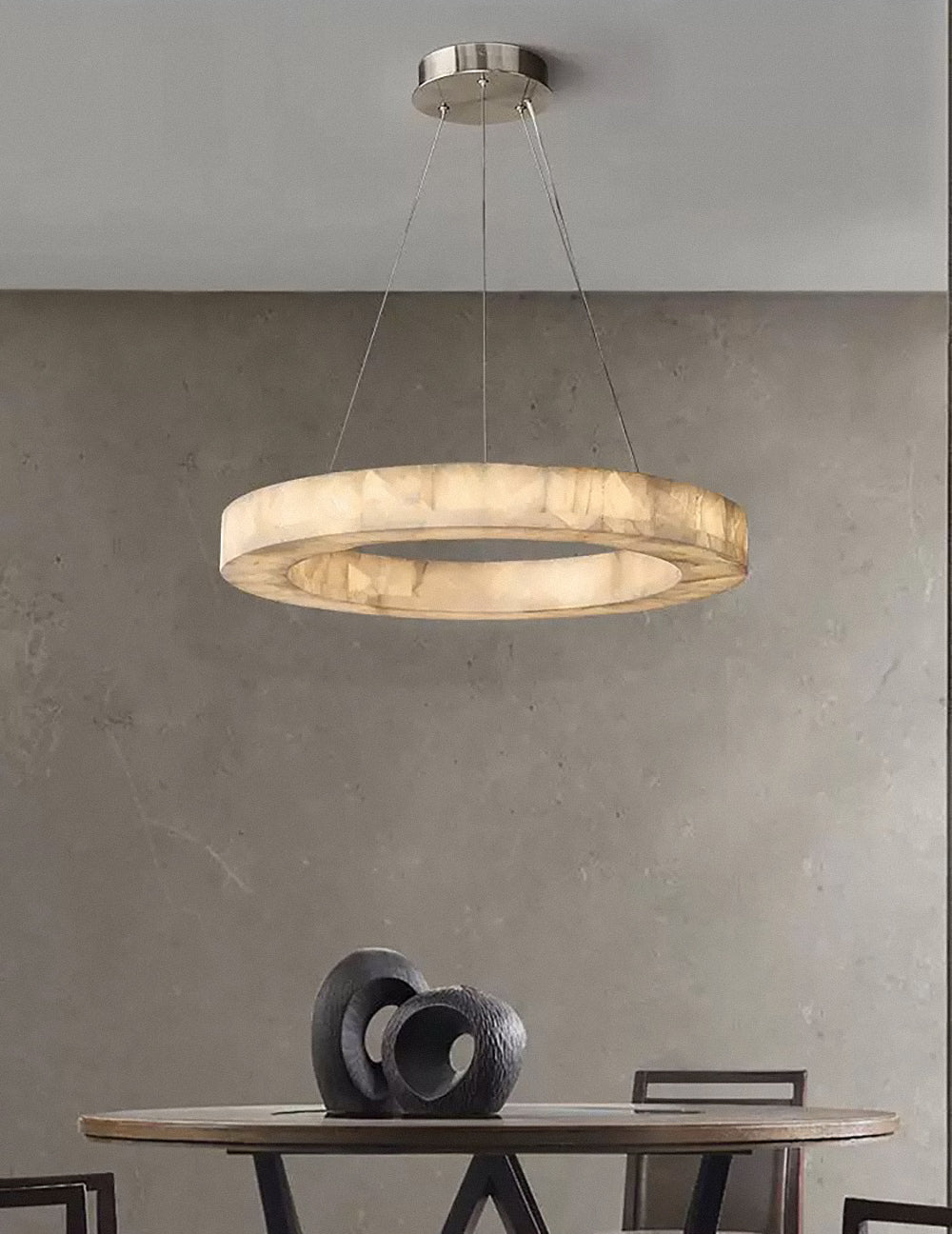 Circoloco circular alabaster chandelier illuminating a modern luxury dining space with an ambient glow.