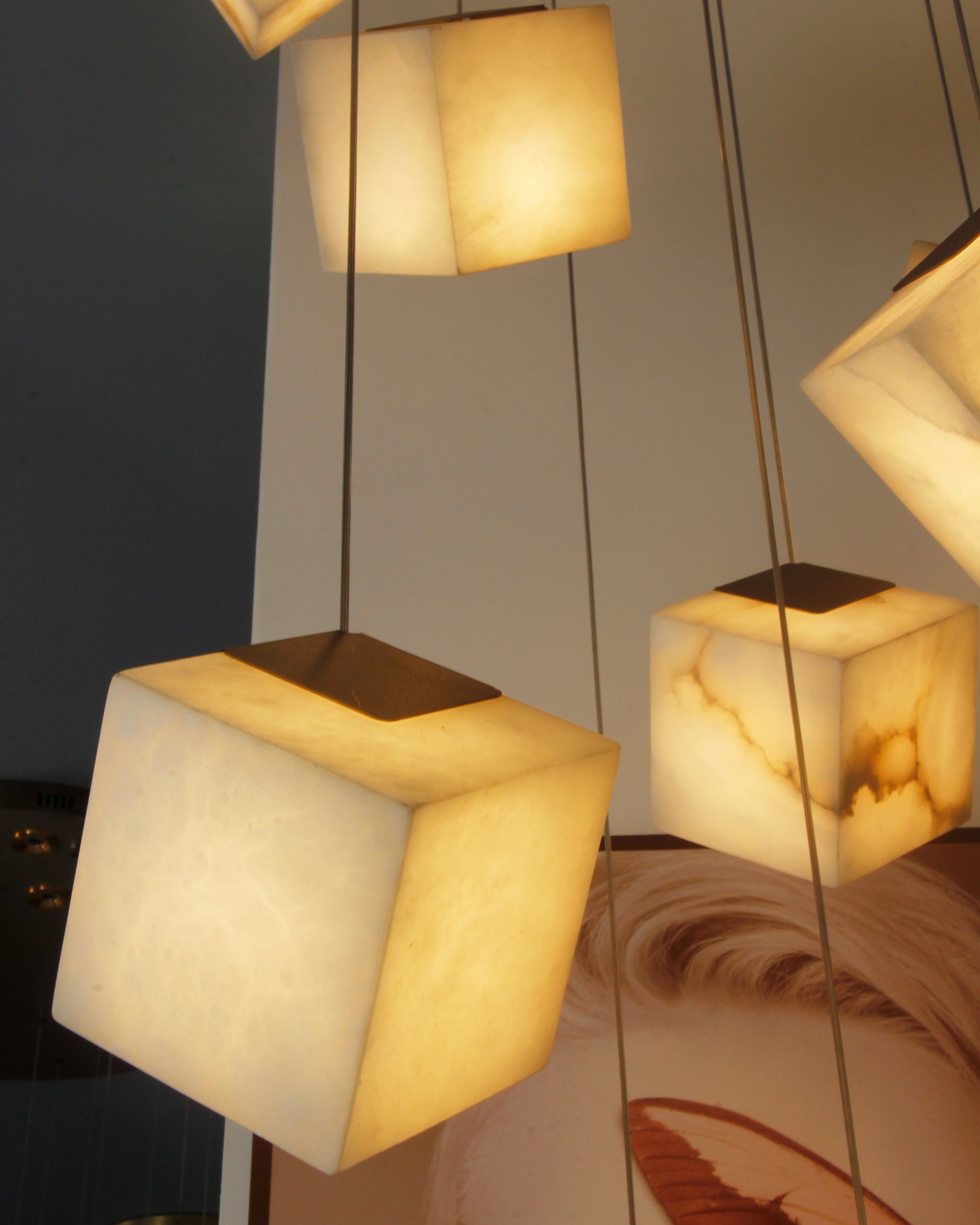 close view of glowing alabaster cube pendants arranged in multiple tiers