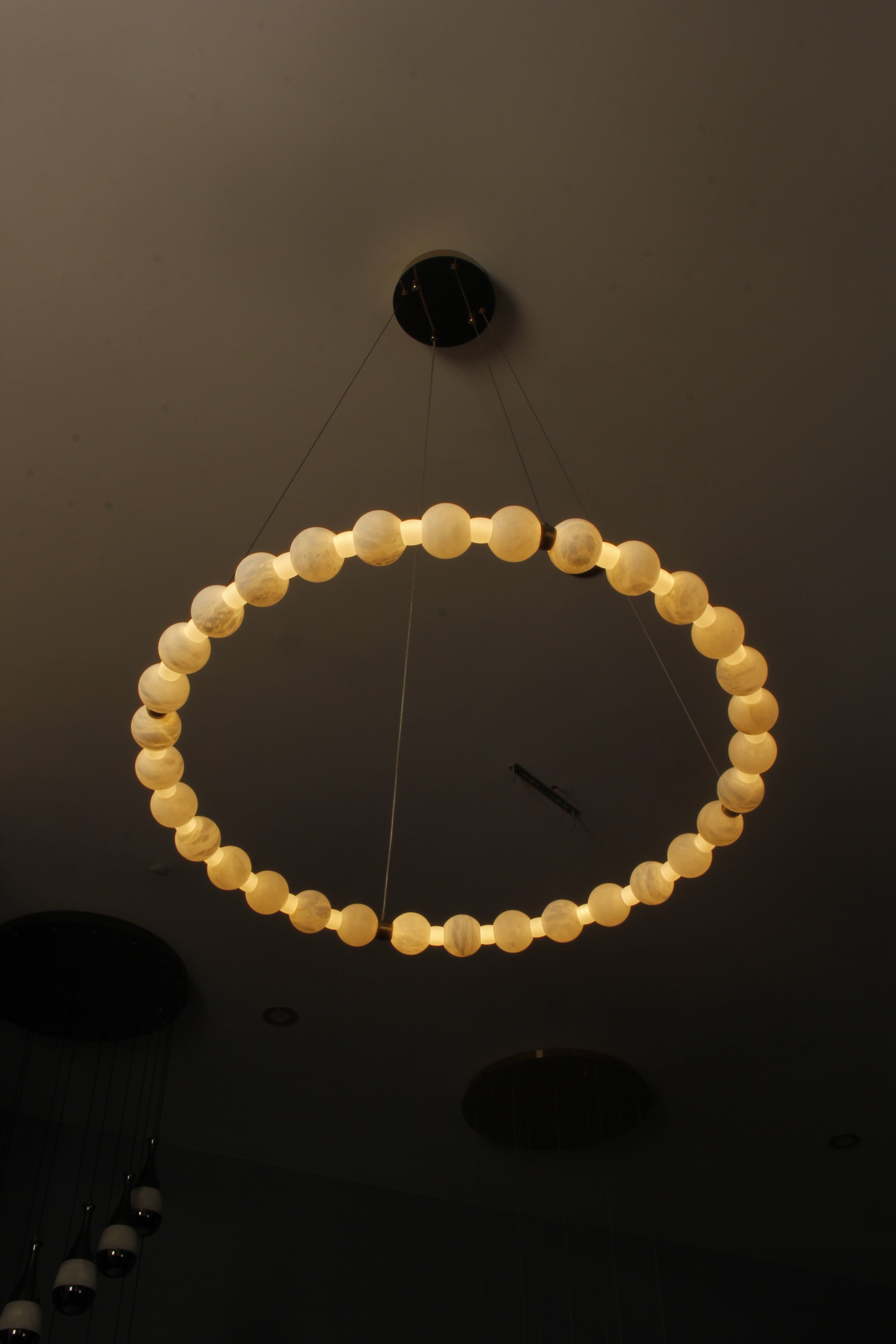 VORELLI® Orbella Marble Circular Chandelier illuminating a modern dining space with celestial glow.