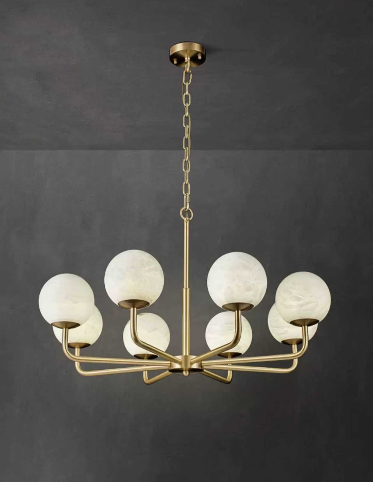 Modern gold chandelier with circular frame and white marble-effect glass globes.