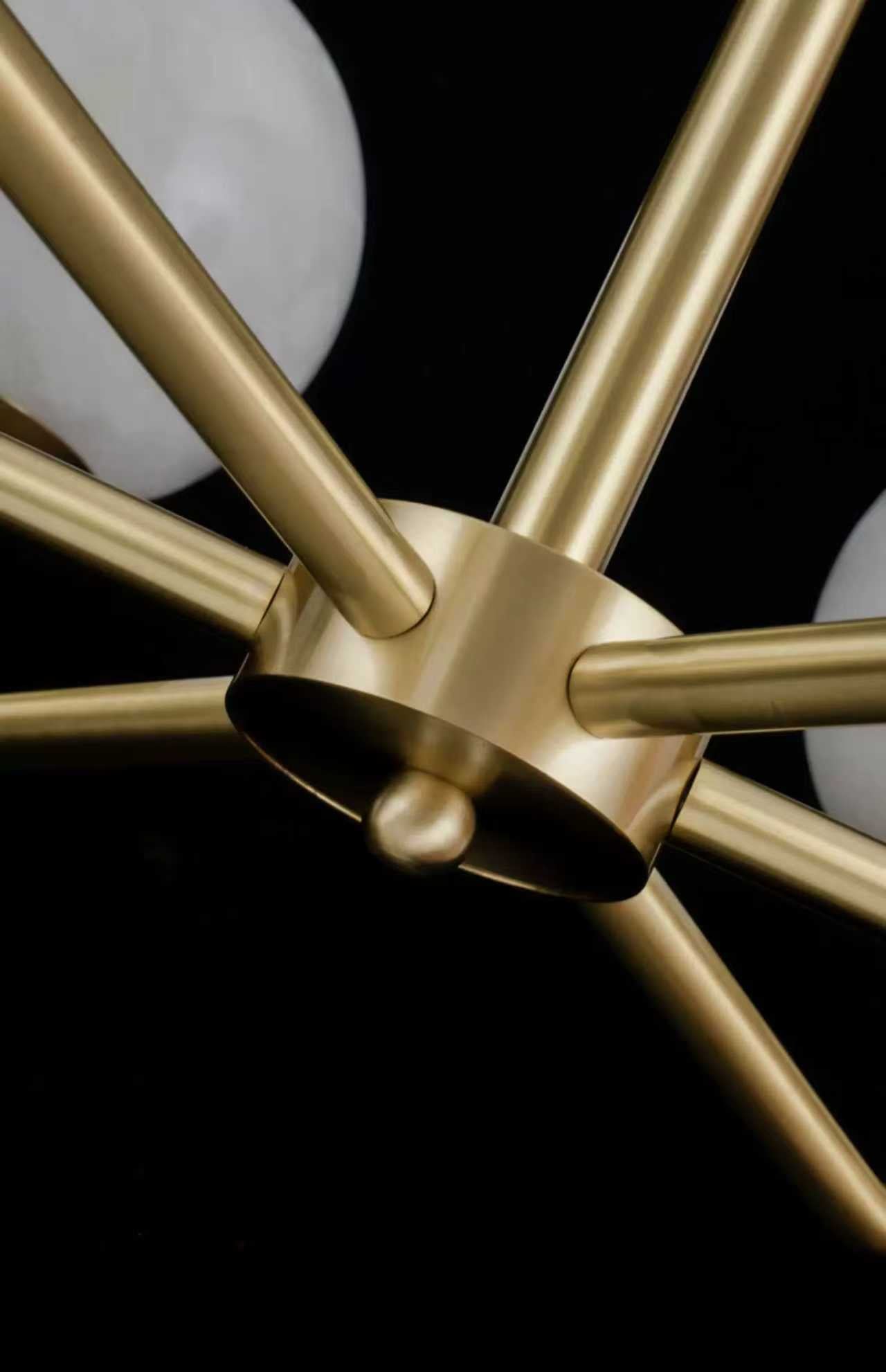 Close-up of brushed gold chandelier frame showing elegant joint detailing.