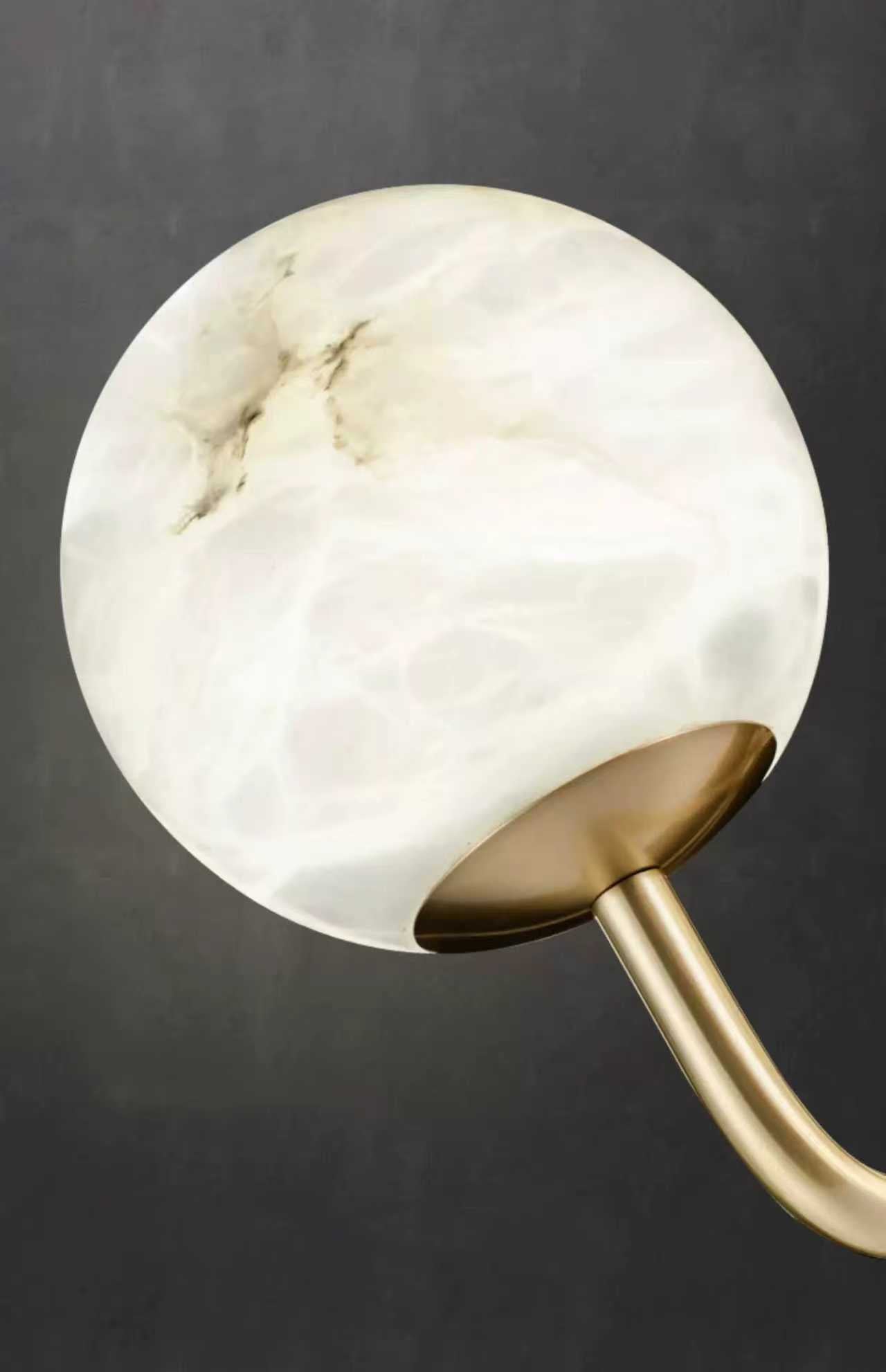 Alabaster-style globe light on gold stem of Ricco Circular Chandelier.