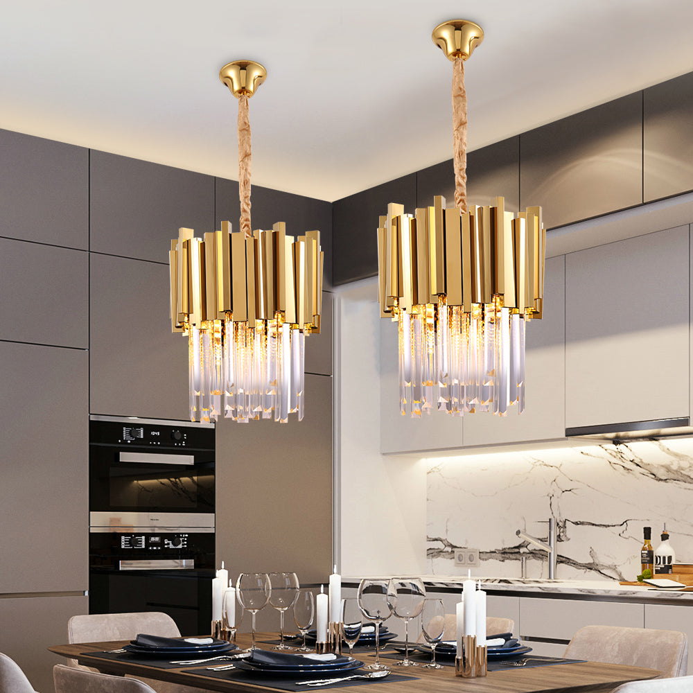 VORELLI® luxury crystal pendant lights above a modern dining table, featuring vertical faceted crystal rods and a sculptural gold frame for high-end residential and hospitality interiors
