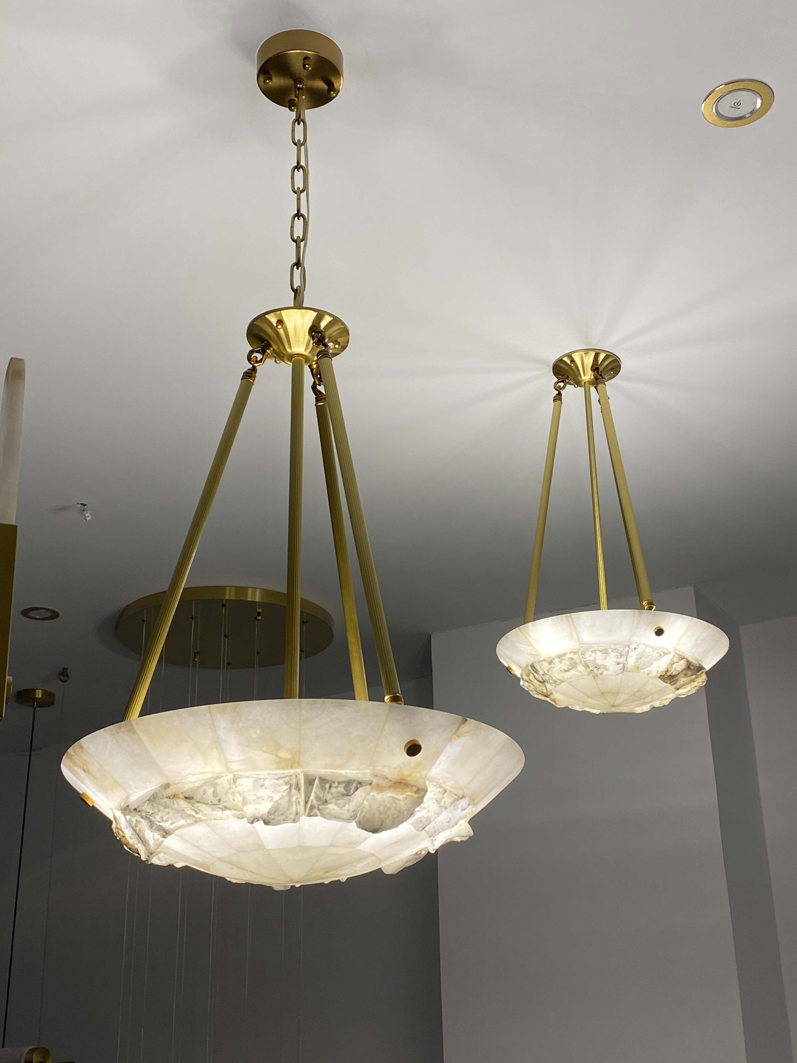 Valleria marble circular chandelier with natural stone disc and brass suspension creating a warm luxury glow