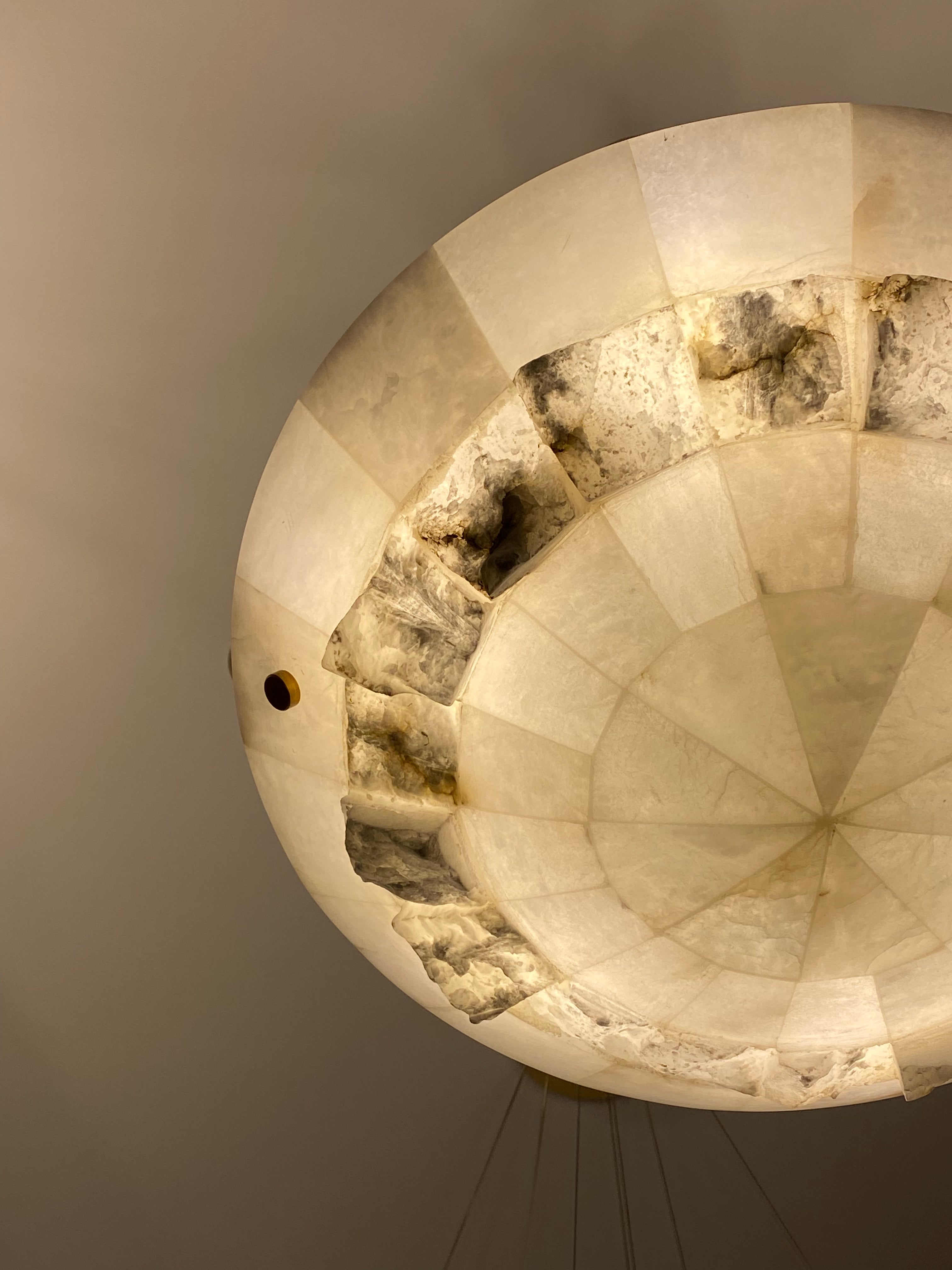 Close-up of Valleria marble circular chandelier showing natural stone texture and warm illumination