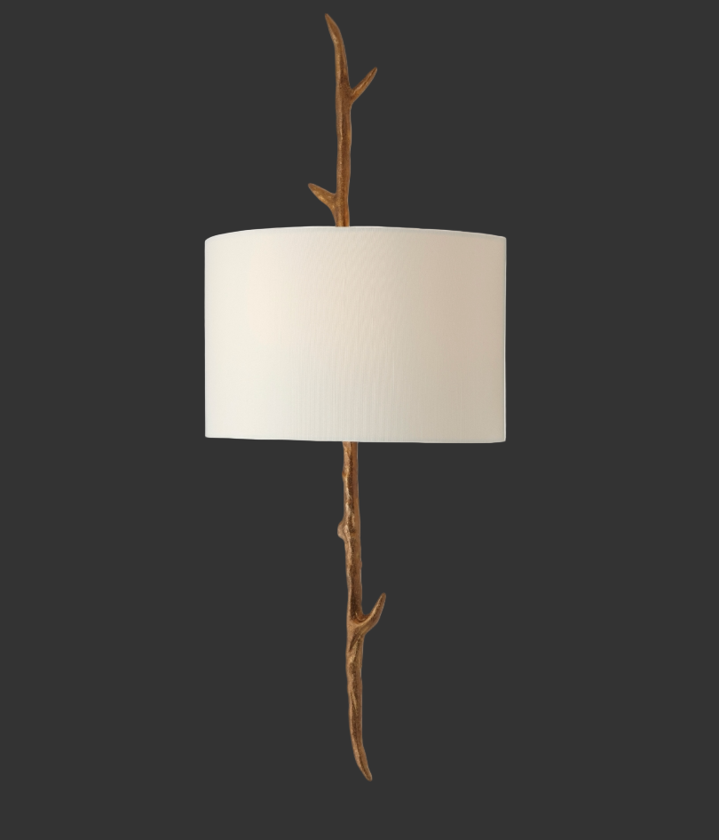 A moody, atmospheric perspective of the Vorelli Verda Wall Light, emphasizing the dramatic contrast between the organic, dark sculptural branch frame and the softly illuminated fabric shade.