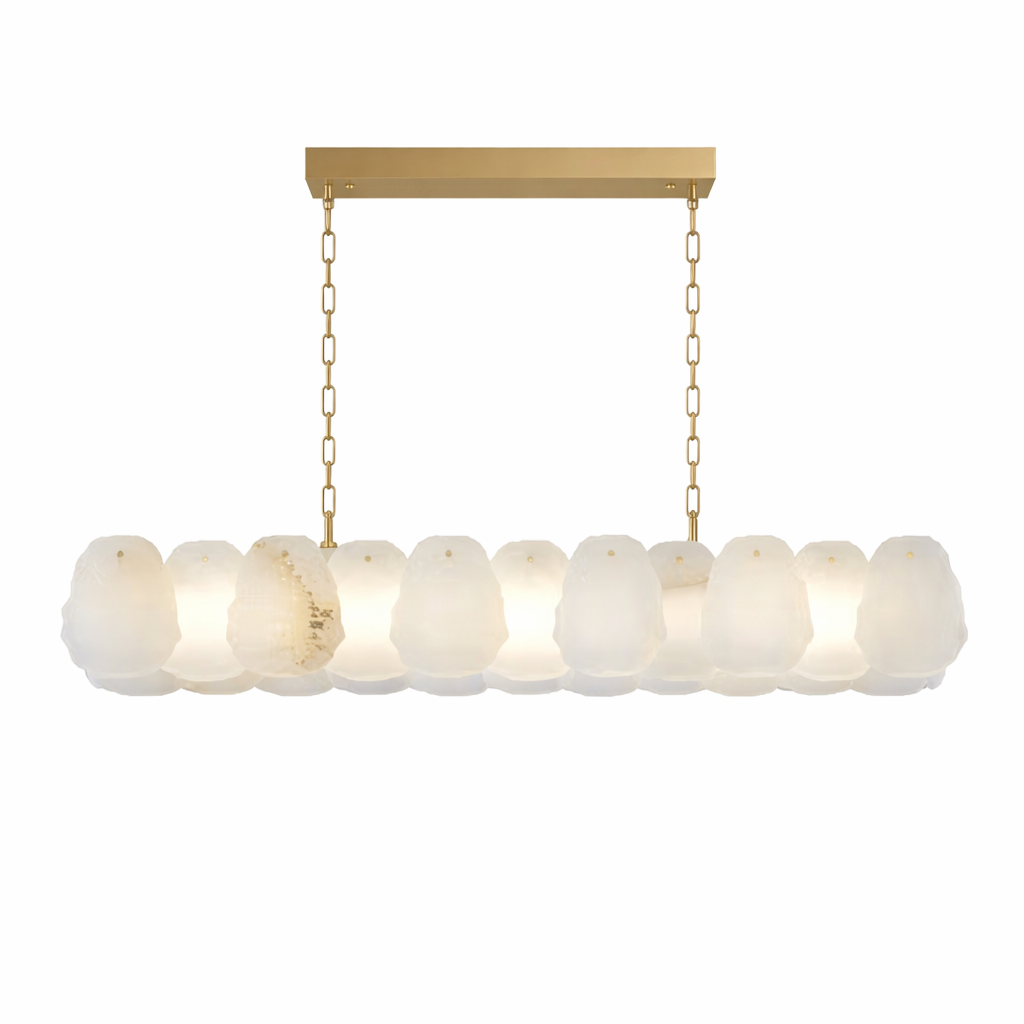 A sophisticated mood shot highlighting the dramatic glow and opulent marble textures of the Silvio rectangular chandelier by VORELLI.