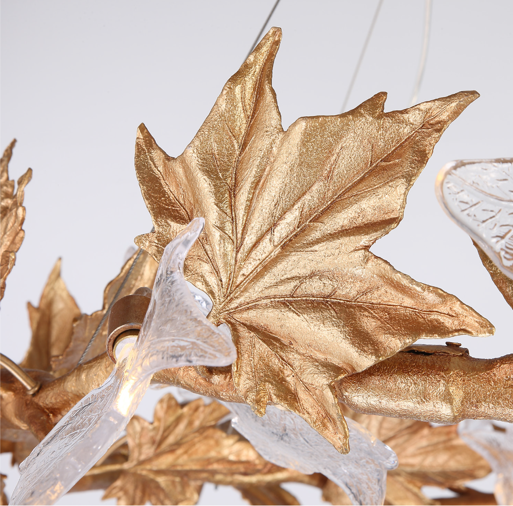 An abstract, mood-focused shot of the VORELLI Maple Grove chandelier, emphasizing the interplay of shadows and soft luxury lighting through its nature-inspired metal leaves.