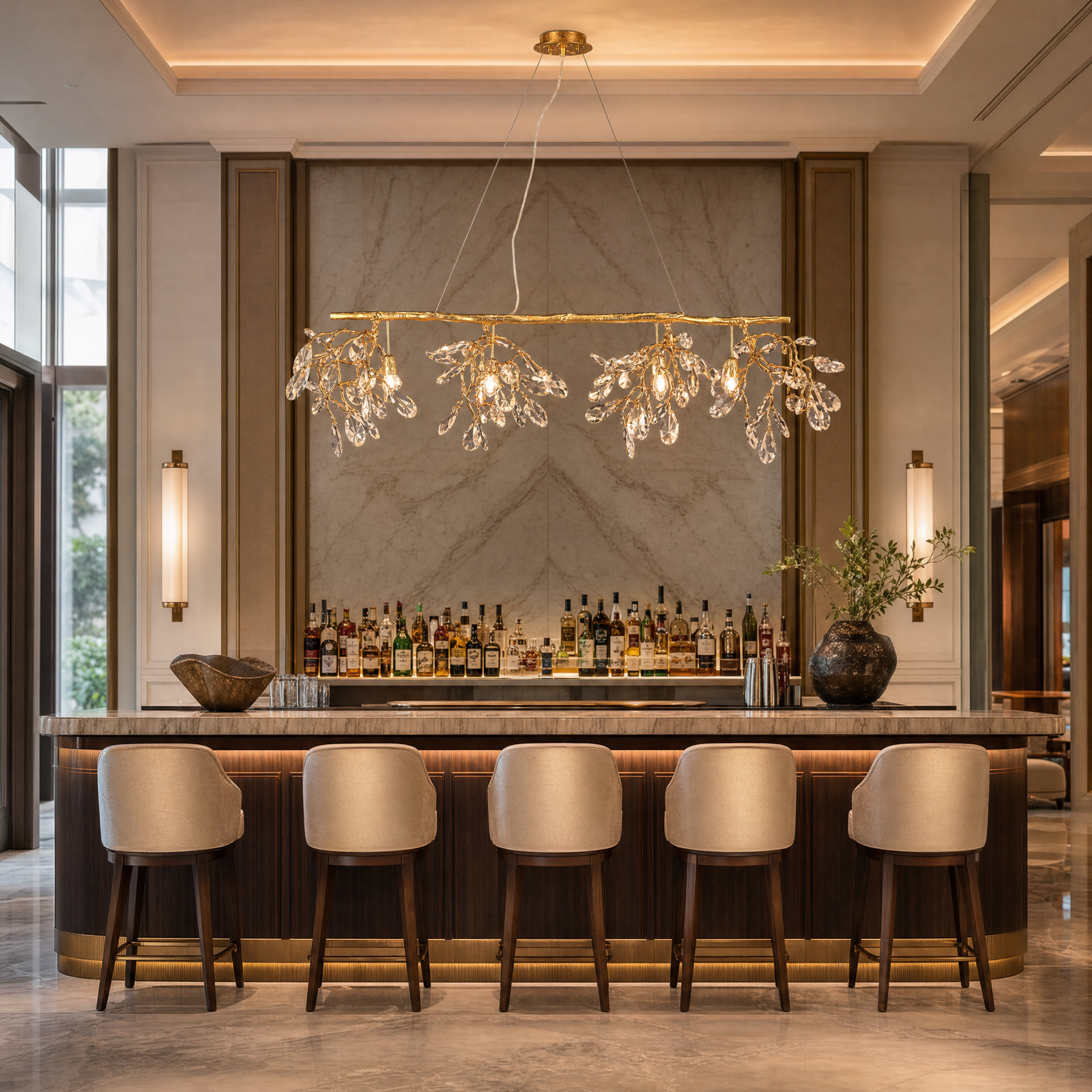 An opulent hospitality lounge featuring the elongated VORELLI Arboré rectangular crystal chandelier suspended over a modern bar area.