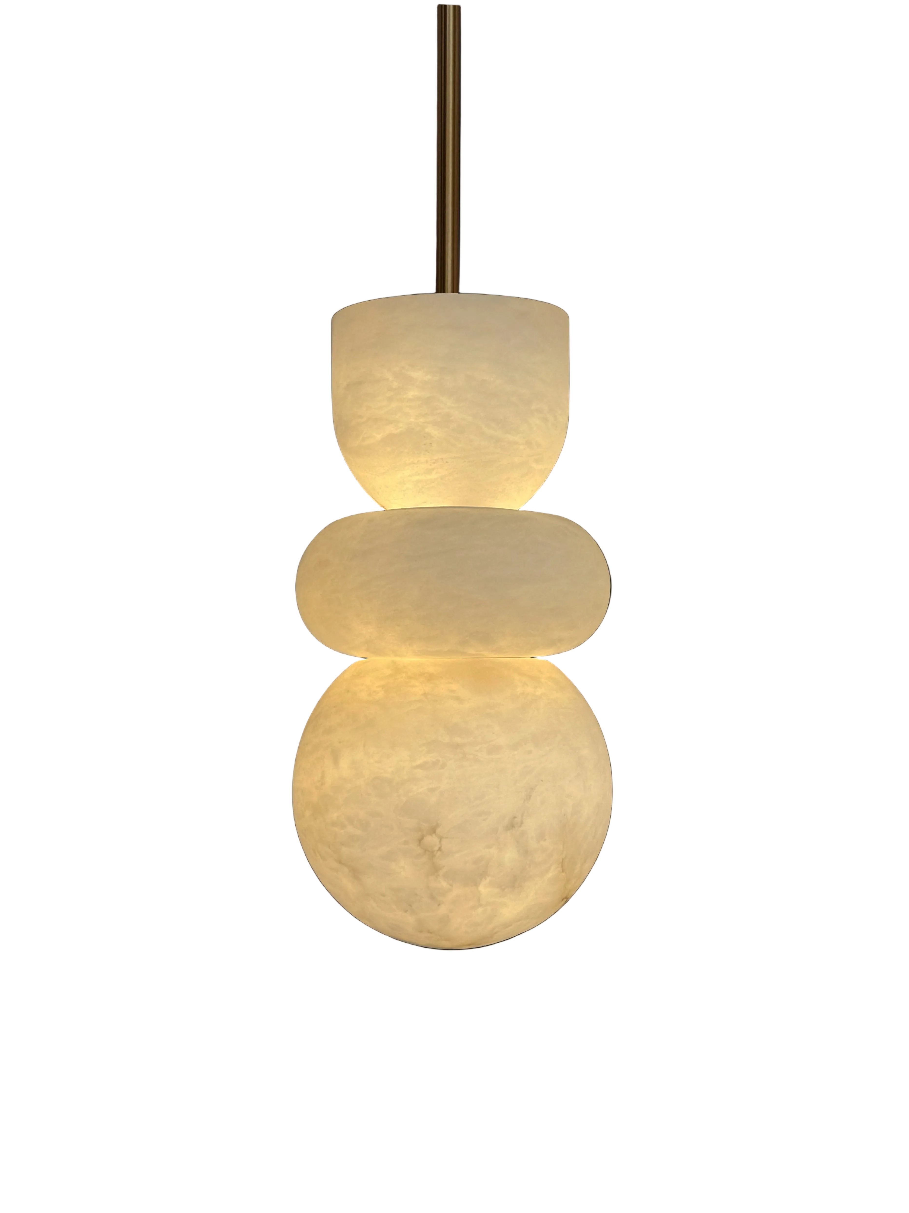 Sculptural pendant light with three stacked glowing marble spheres suspended from ceiling.