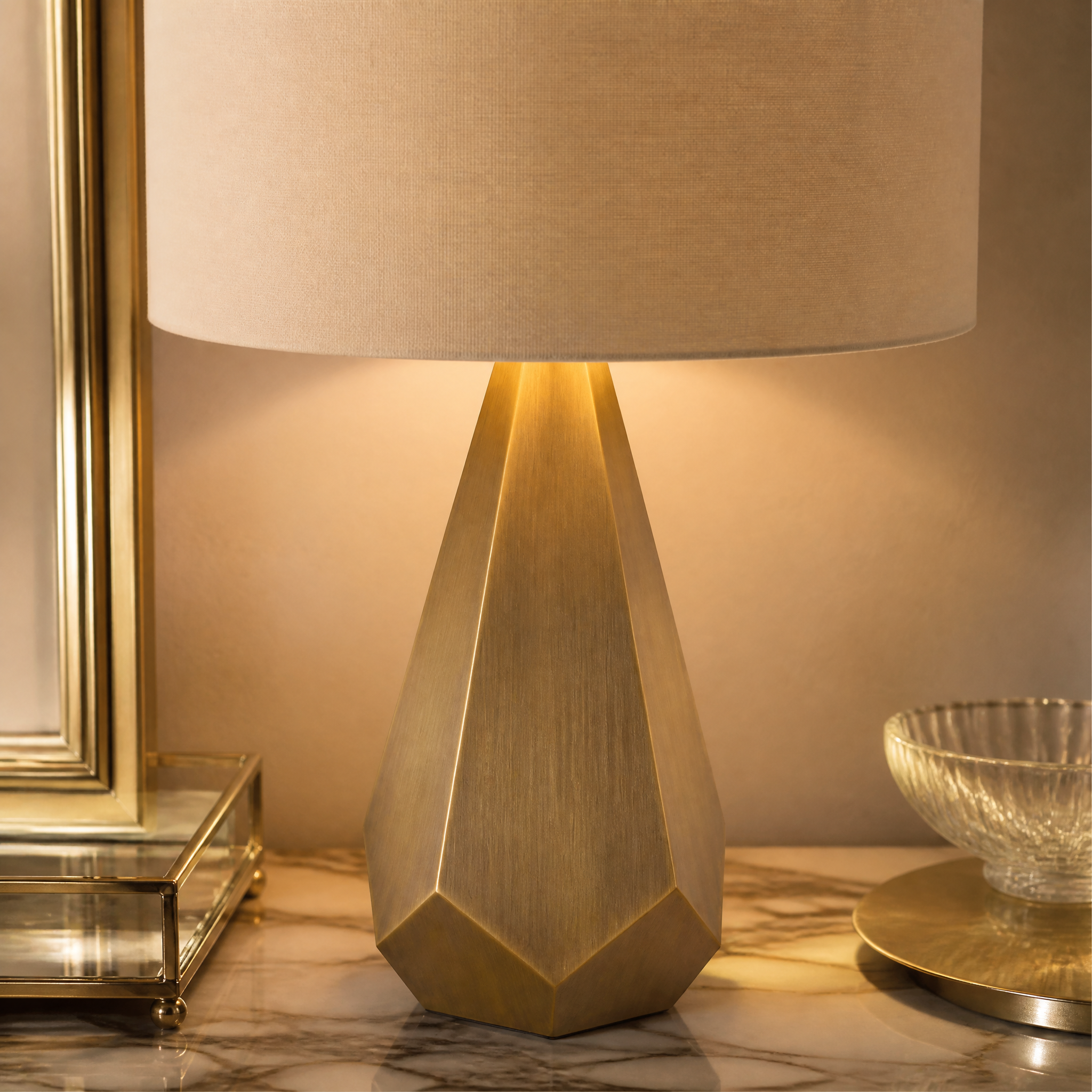 A detailed closeup of the Arvion table lamp showcasing the intricate faceted texture of its antique brass sculpted base and premium fabric shade.