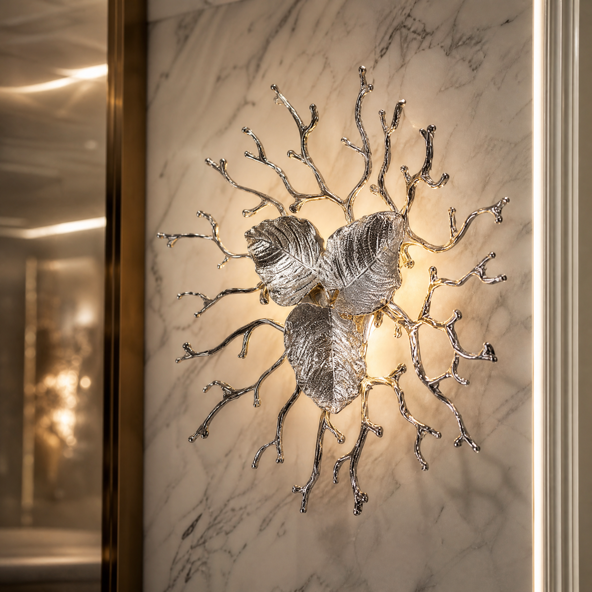 Macro view of the VORELLI Aurelia Wall Light III, highlighting the intricate texture of the three metallic leaves and organic branch arms.