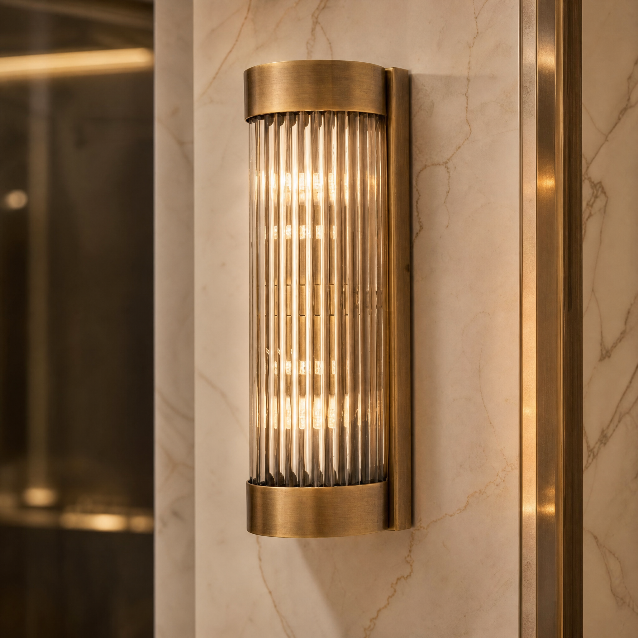 Close-up of the Aurelio wall light showing the rich antique brass finish and vertically ribbed glass texture