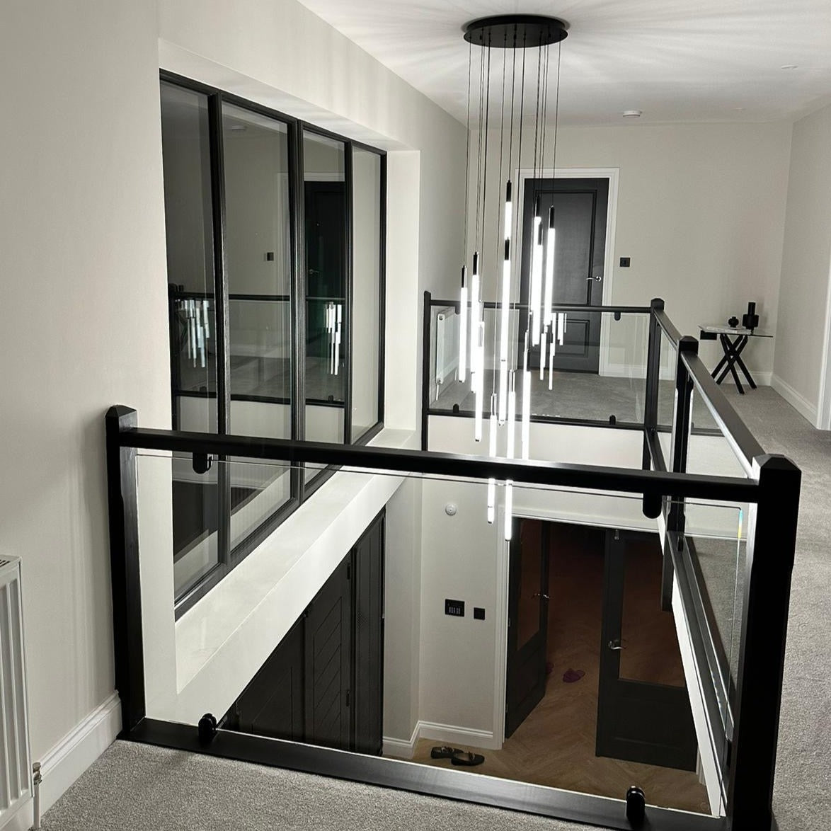 Avezzano Pendant Chandelier in a minimalist staircase and dining room setting.