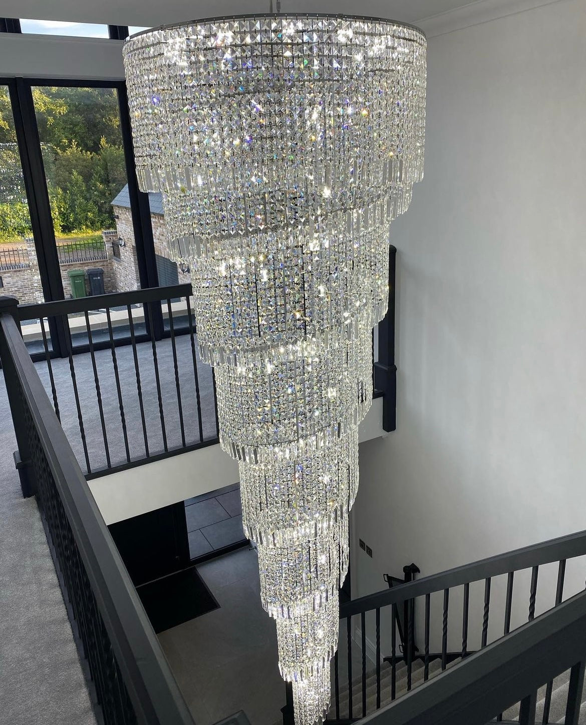 Basilgio Spiral Staircase Chandelier installed in a modern interior with full-height drop.