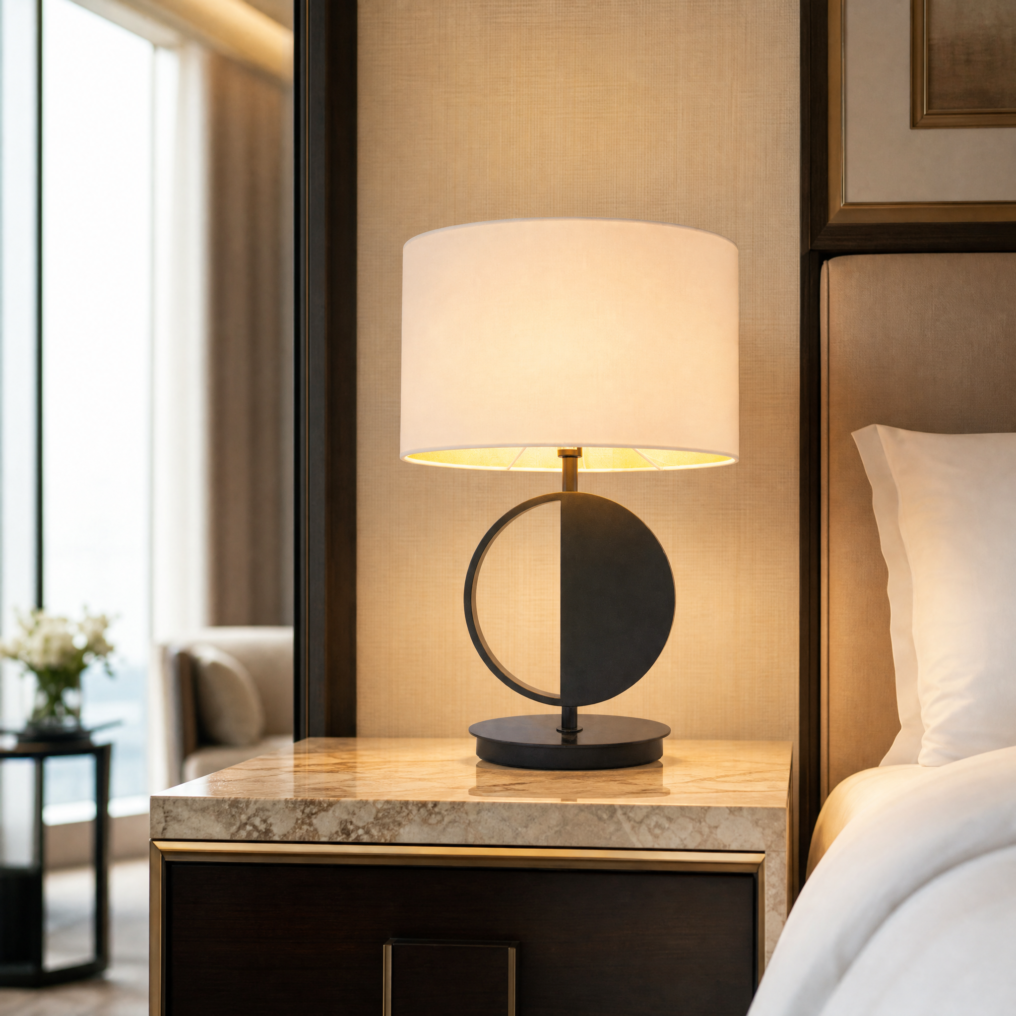 Elegant Bravon brass and bronze lamp providing warm ambient lighting on a luxury hotel bedside table
