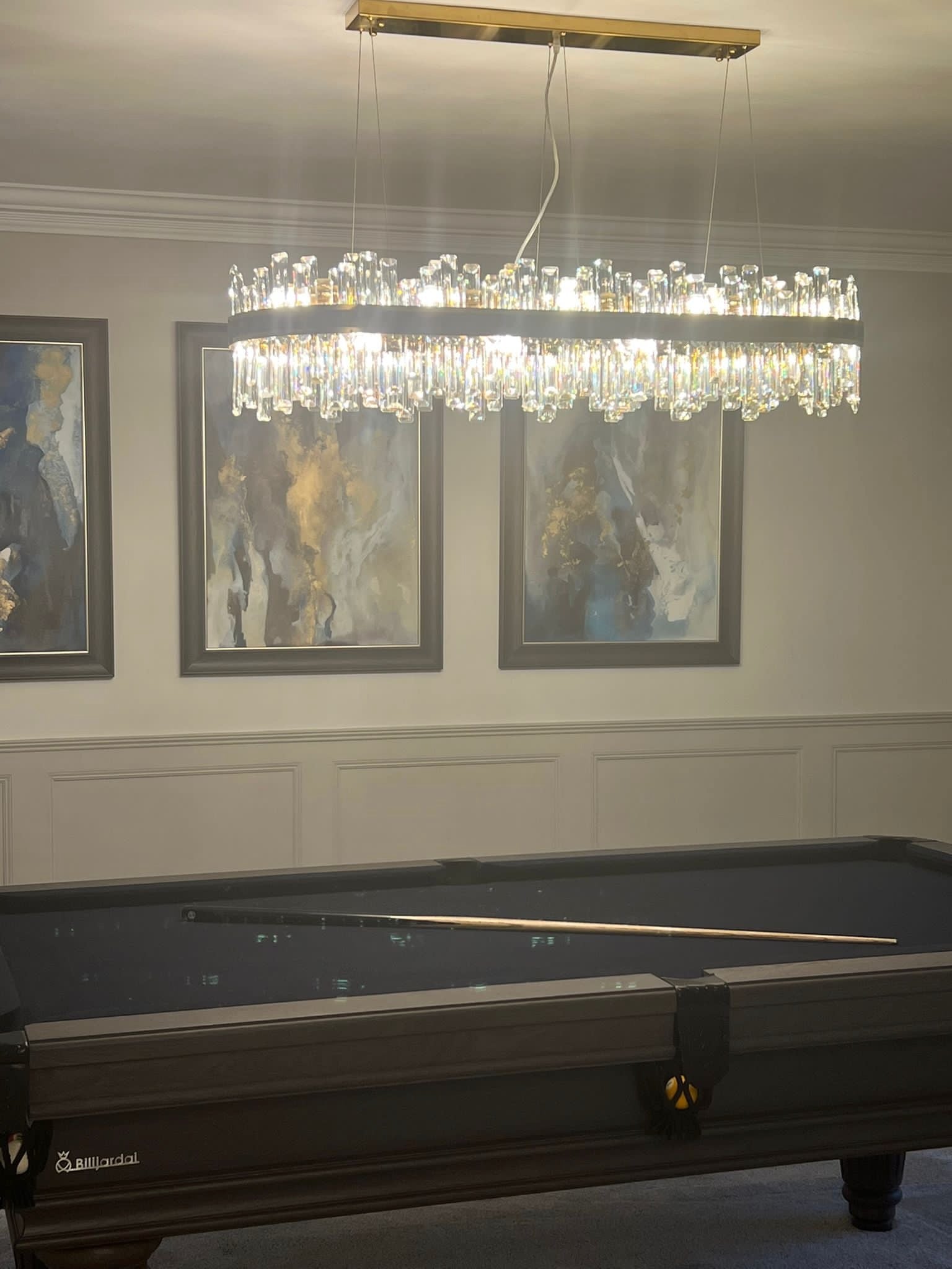 Brighouse rectangular chandelier illuminating a luxury dining room in the evening