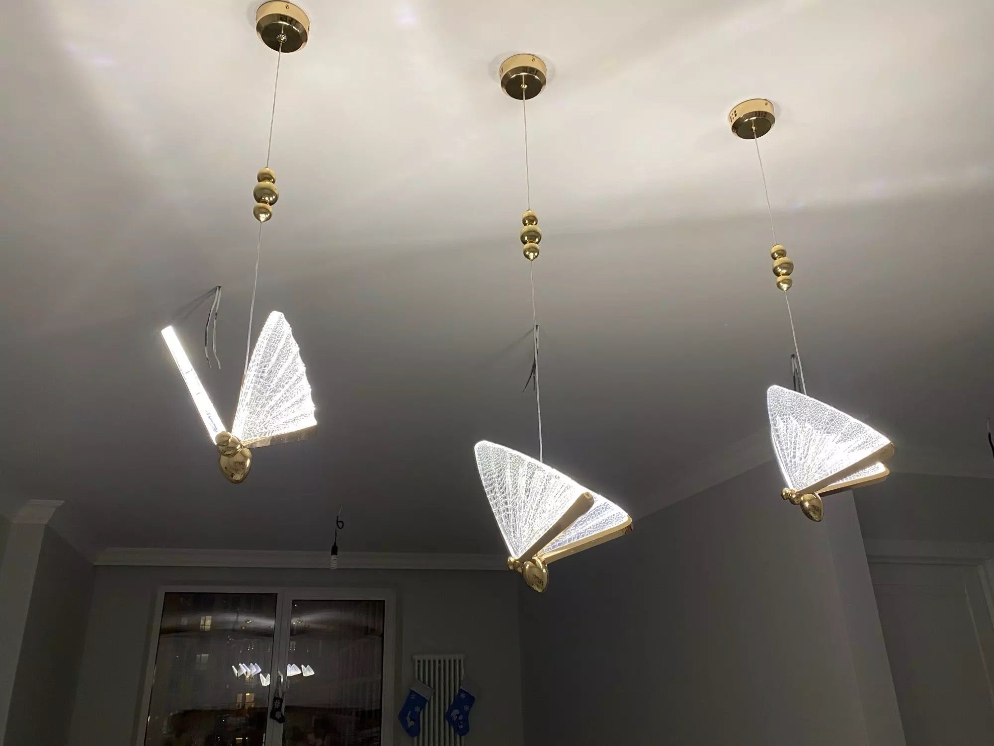 Three butterfly pendant lights installed above modern interior space