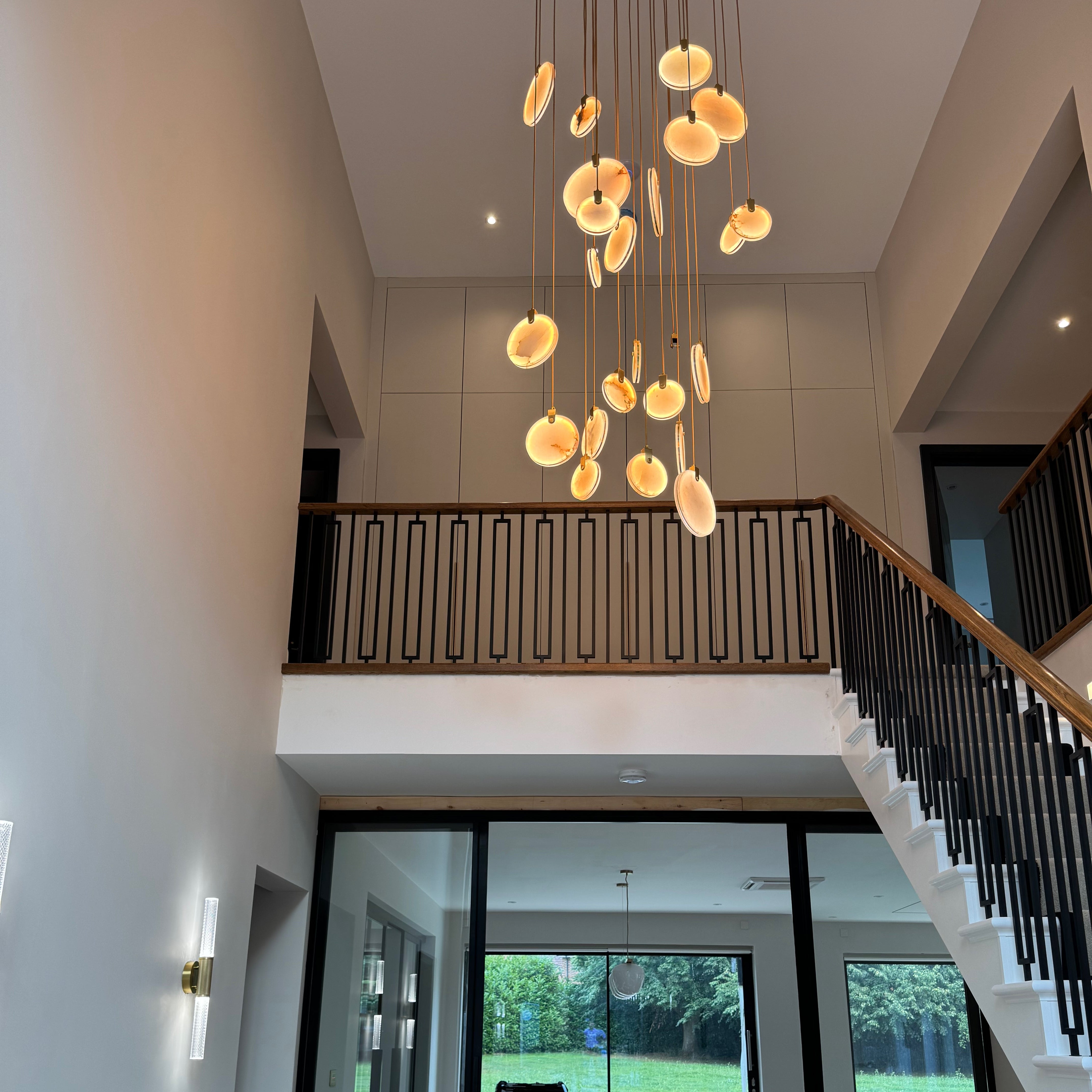 Luxury Calacatta marble chandelier framed within a modern staircase architectural opening.
