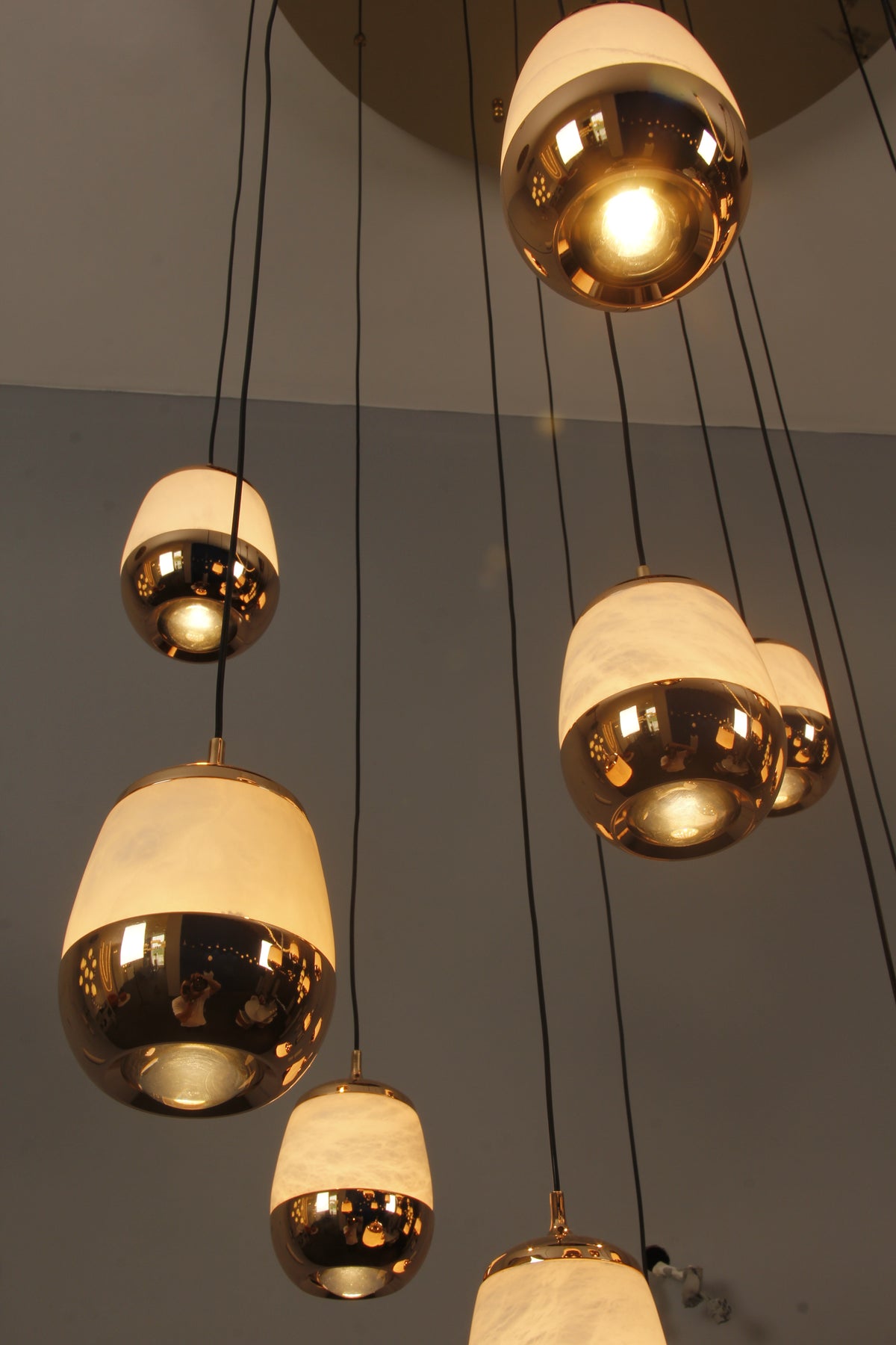 Angled view of suspended Caldera marble pendants revealing depth and cascading vertical movement.