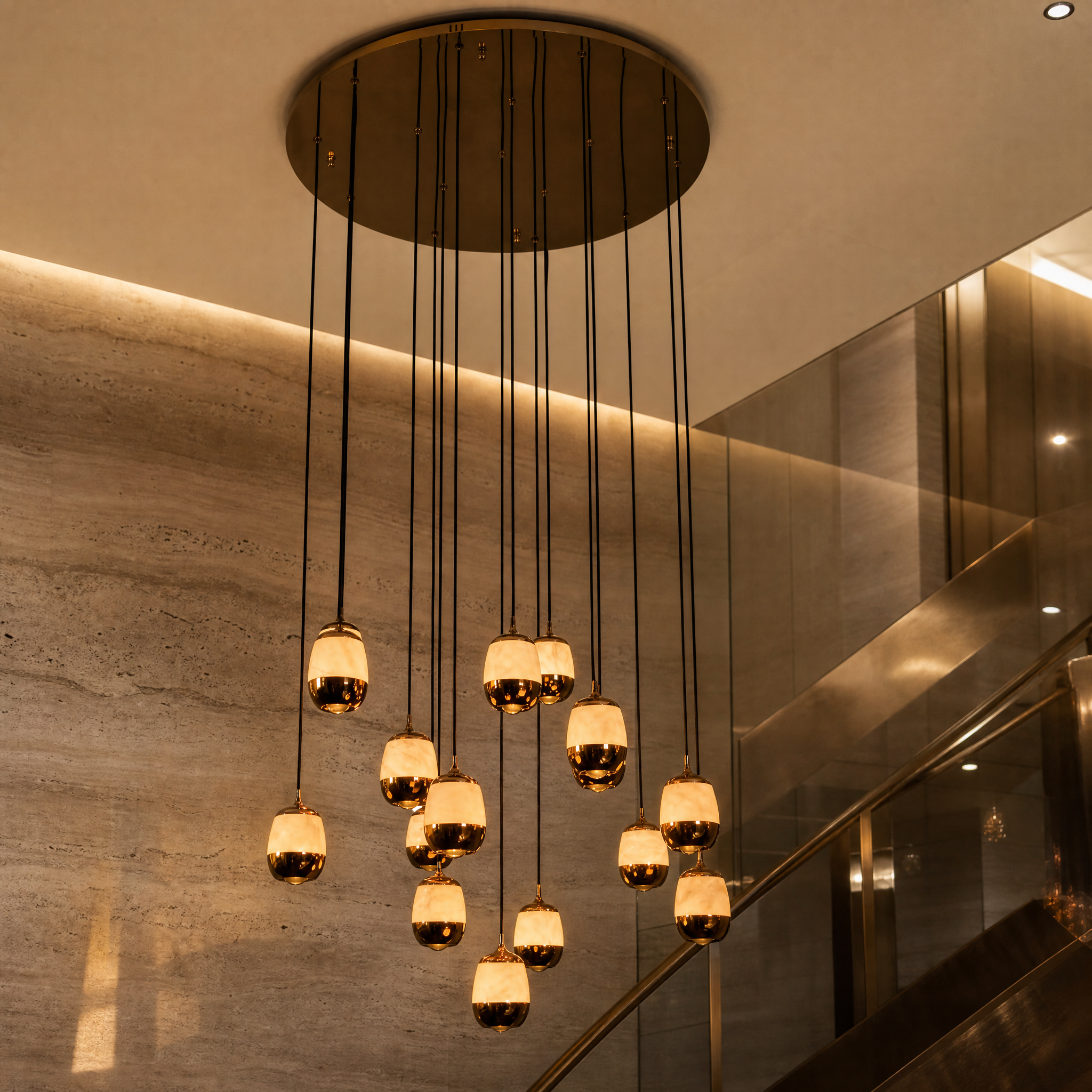 A detailed closeup of the VORELLI Caldera Chandelier, highlighting the natural textures of the sculptural marble drops and the soft, glowing illumination.