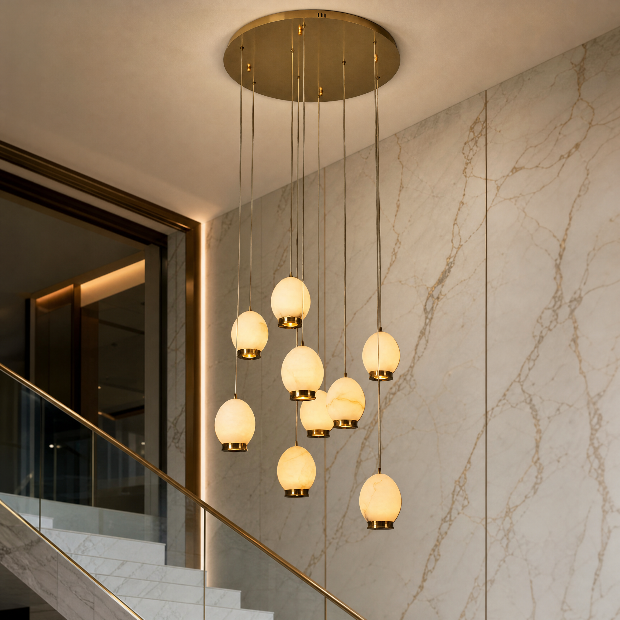 A detailed close-up shot of the VORELLI Caledonia chandelier, highlighting the soft texture of the natural floating marble shades and refined brass metal accents.