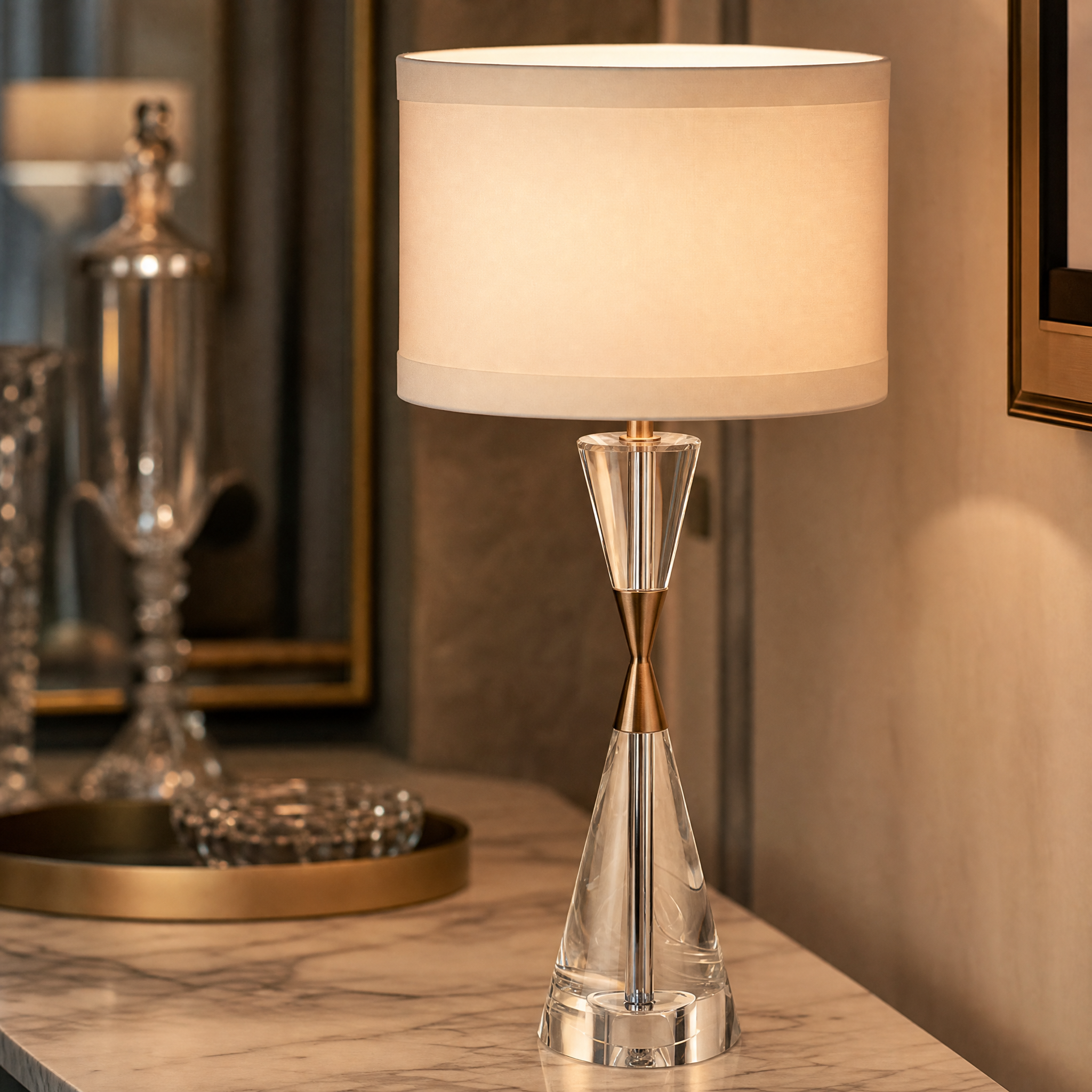 Close-up of the Dalmora table lamp highlighting the refined clear crystal hourglass base and warm antique brass metallic accents.