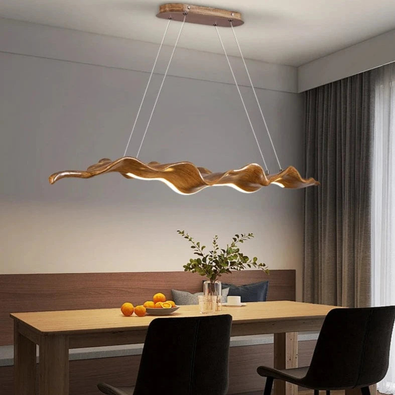 contemporary illuminated wave chandelier installed above dining table