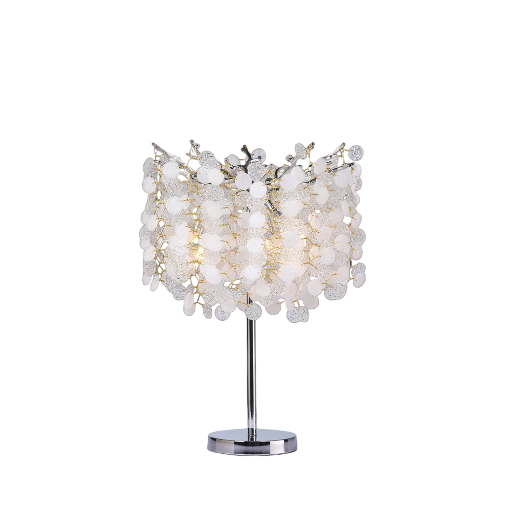 Detailed closeup of the Vorelli Lunaria Table Lamp showing the warm decorative glow filtering through textured glass coin-like crystals.