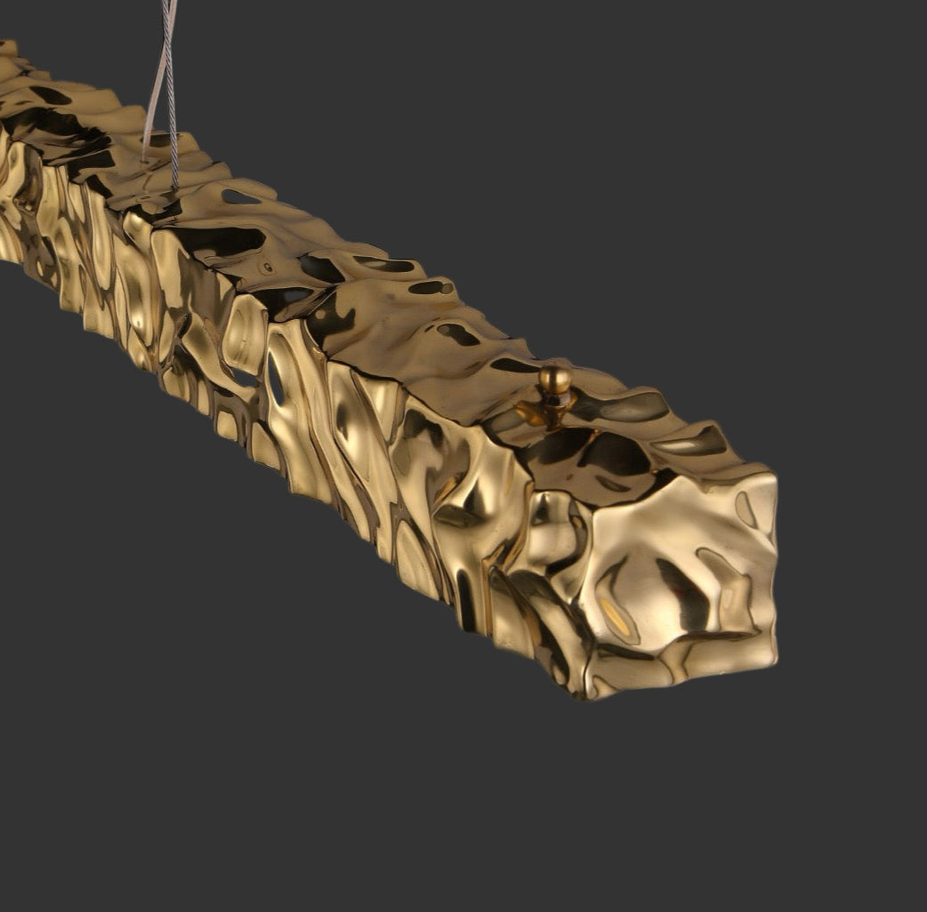 Close-up detail of the textured gold surface on the Ecliptica rectangular chandelier by VORELLI®