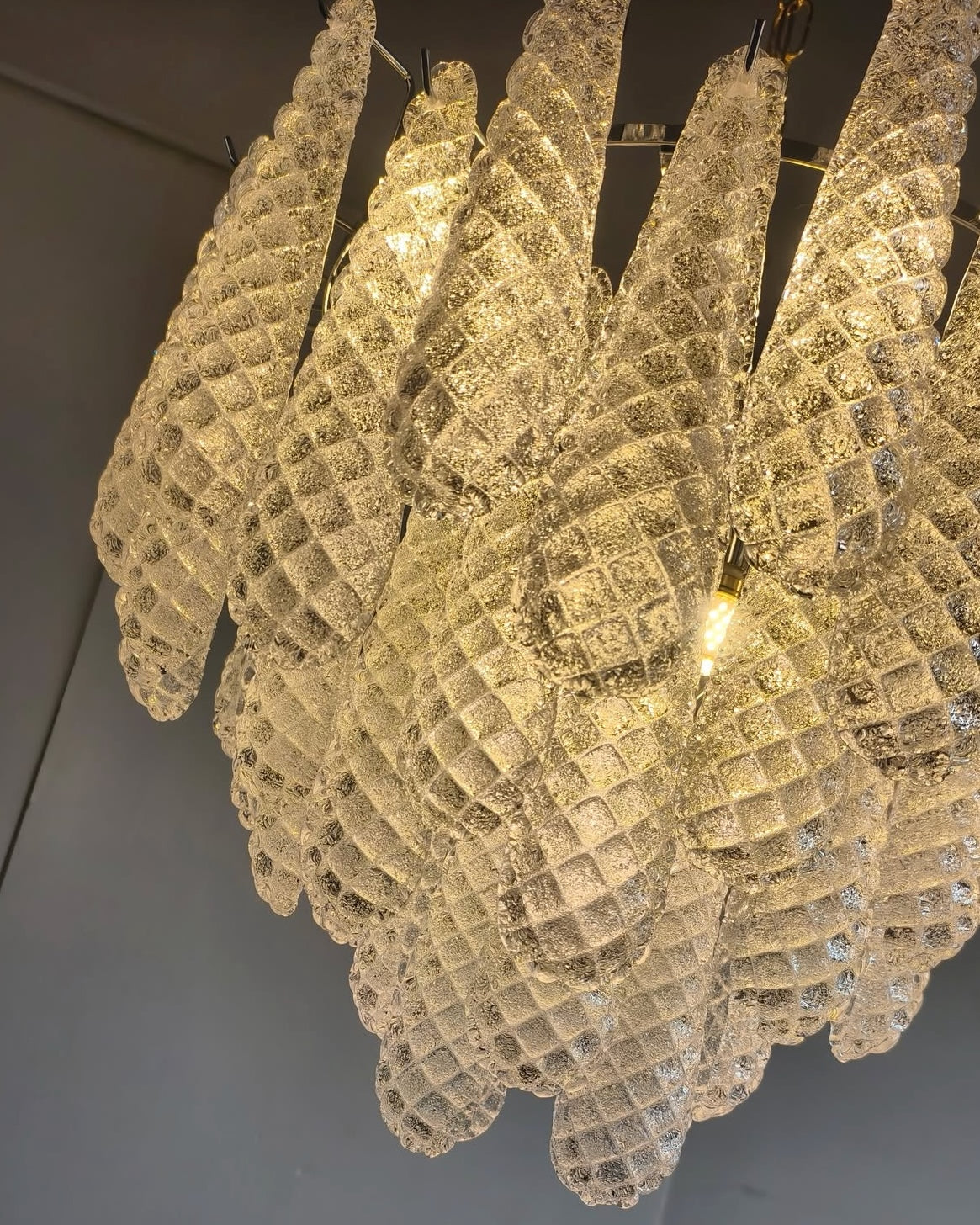 Angled view of the Eclissi Circular Chandelier showcasing layered glass form and sculptural lighting design