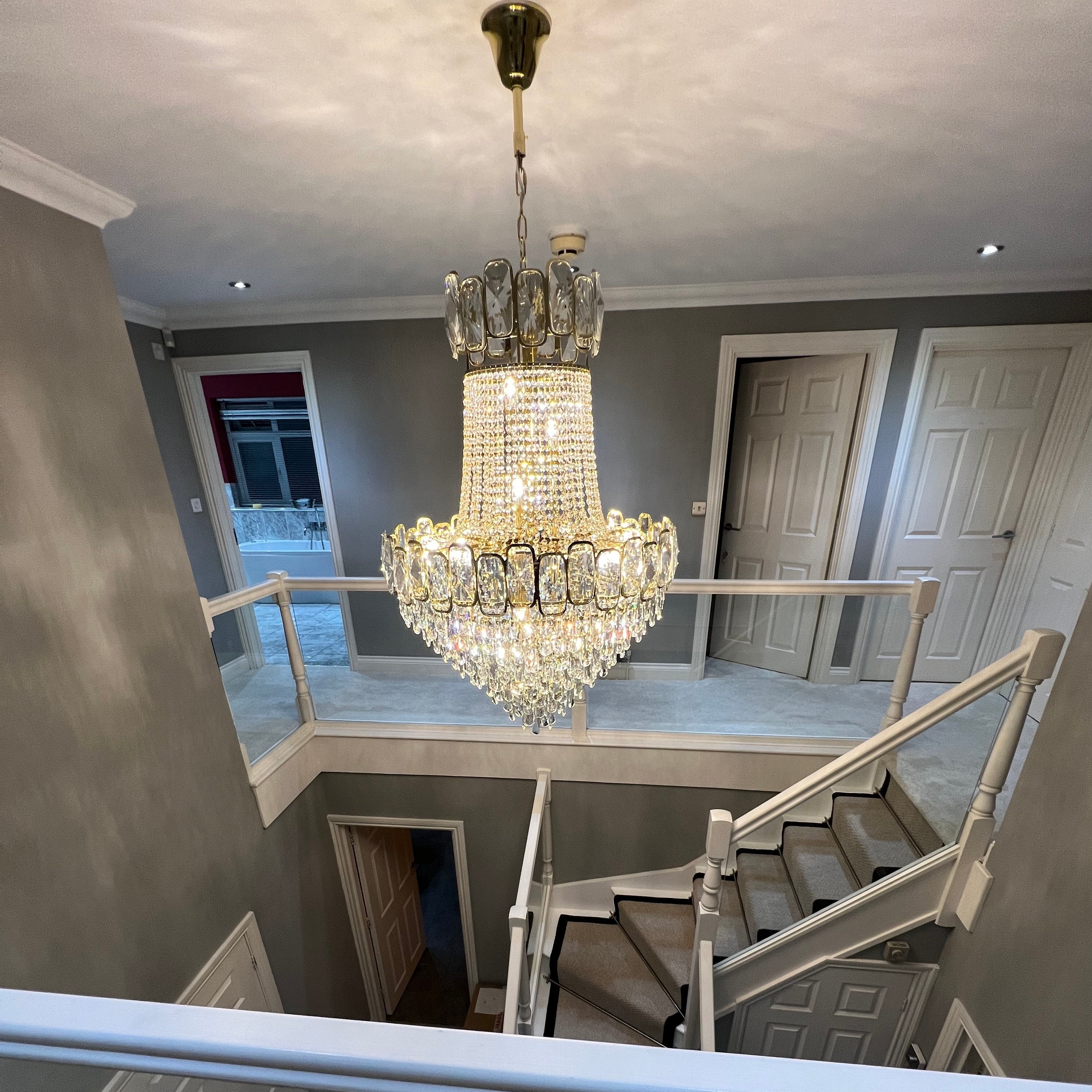 Grand entryway featuring the Edison Grandeur chandelier with traditional crystal styling by VORELLI®