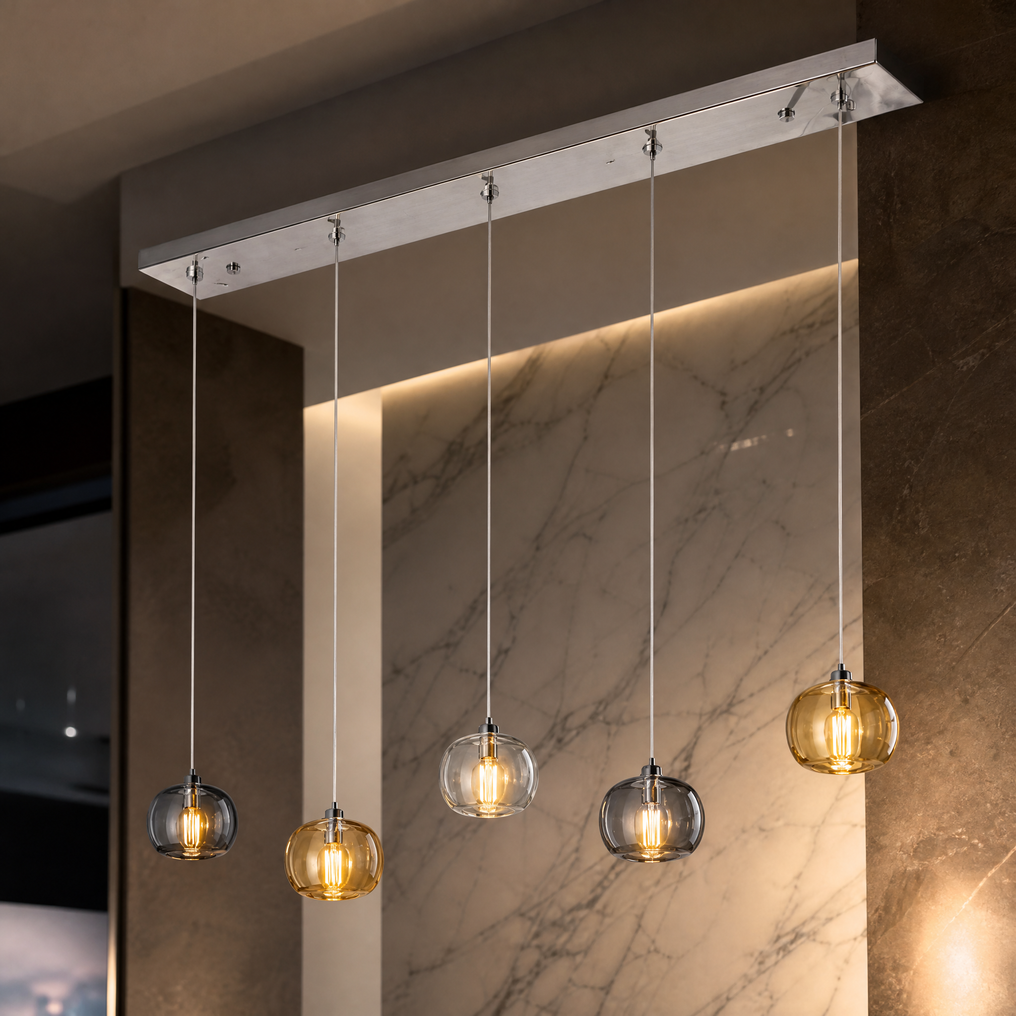 A detailed macro closeup of the sleek amber, clear, and smoky grey crystal globe pendants from the VORELLI Emiliano modern rectangular chandelier.
