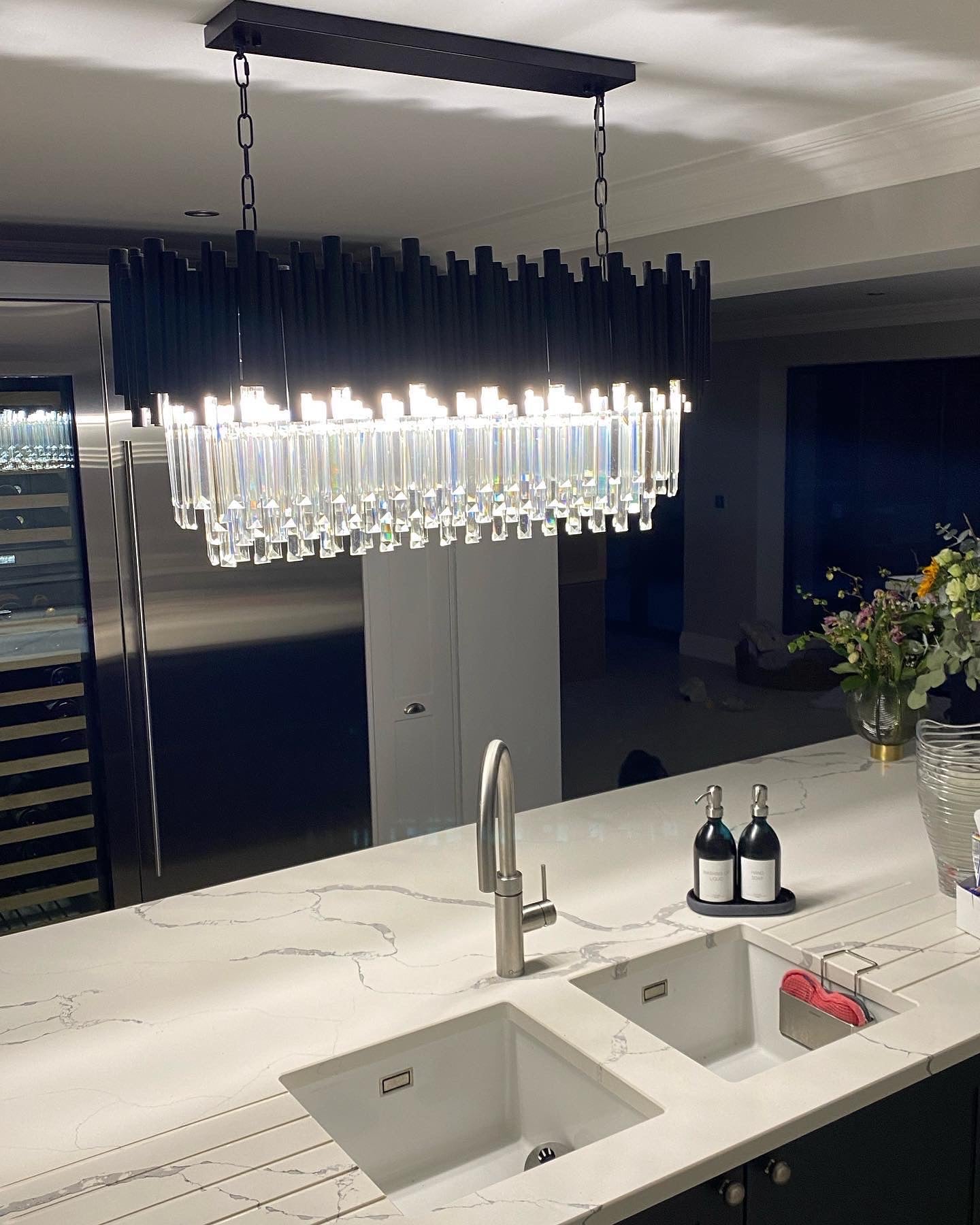 Gotham rectangular chandelier creating warm ambient lighting in a modern kitchen