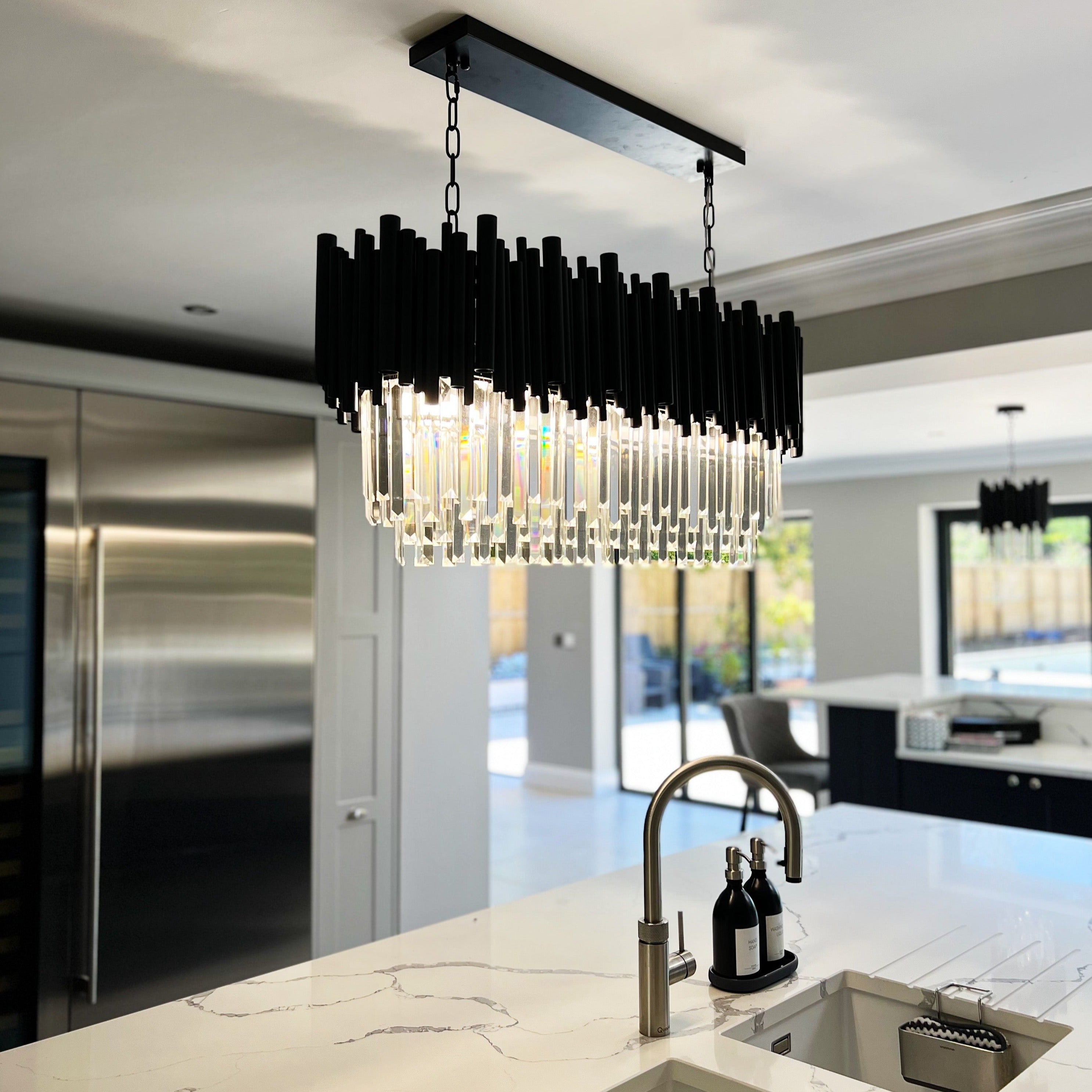 Gotham rectangular chandelier above a modern kitchen island with crystal detailing